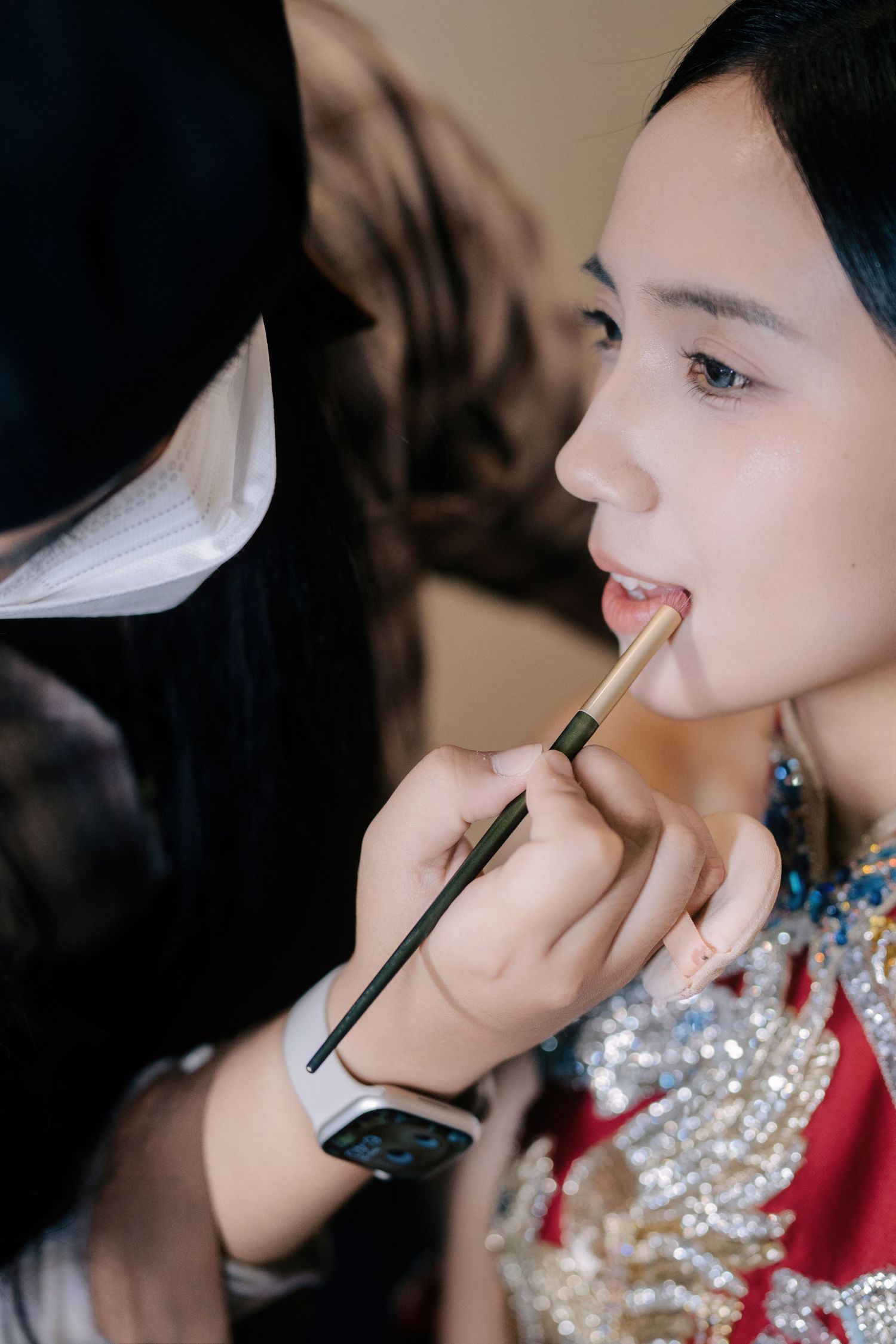 Close-up of a bridal makeup artist applying lipstick for a bride during her morning transformation