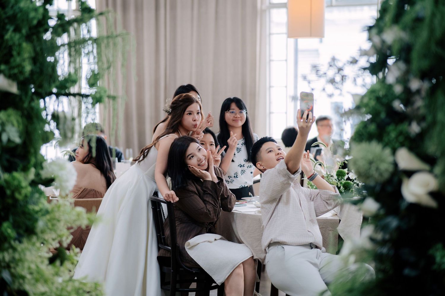 Fun group photo at Peninsula House Penang wedding reception showing the venue's elegant indoor decor