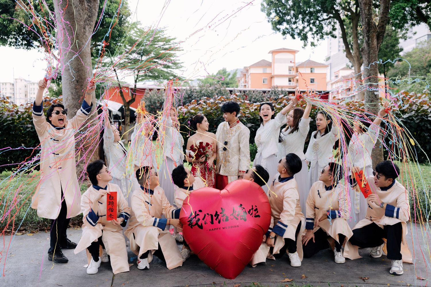 Wedding party jumping for a fun group photo outdoors in coordinated white outfits.