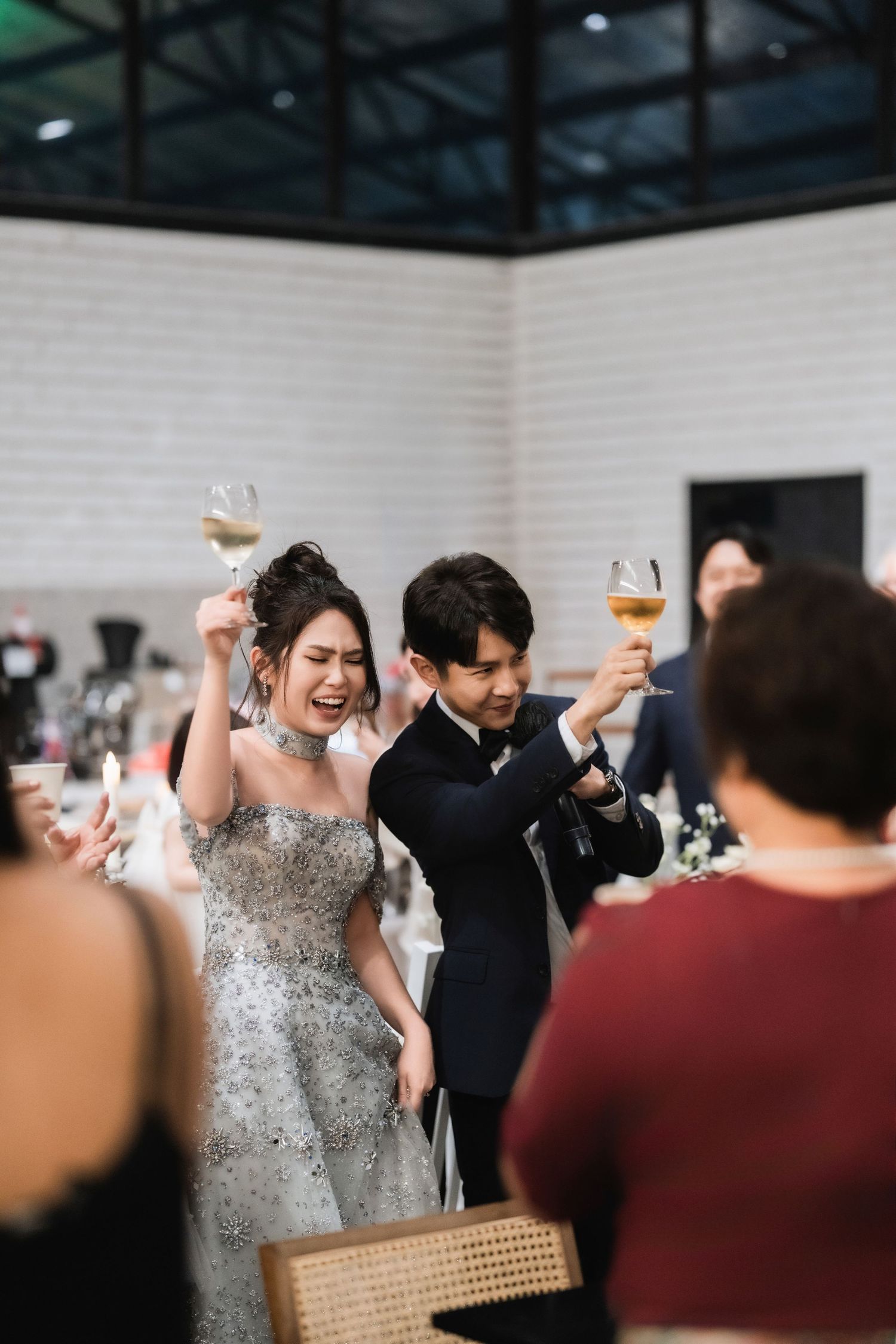 Wedding guests raise their glasses in celebration during the reception.