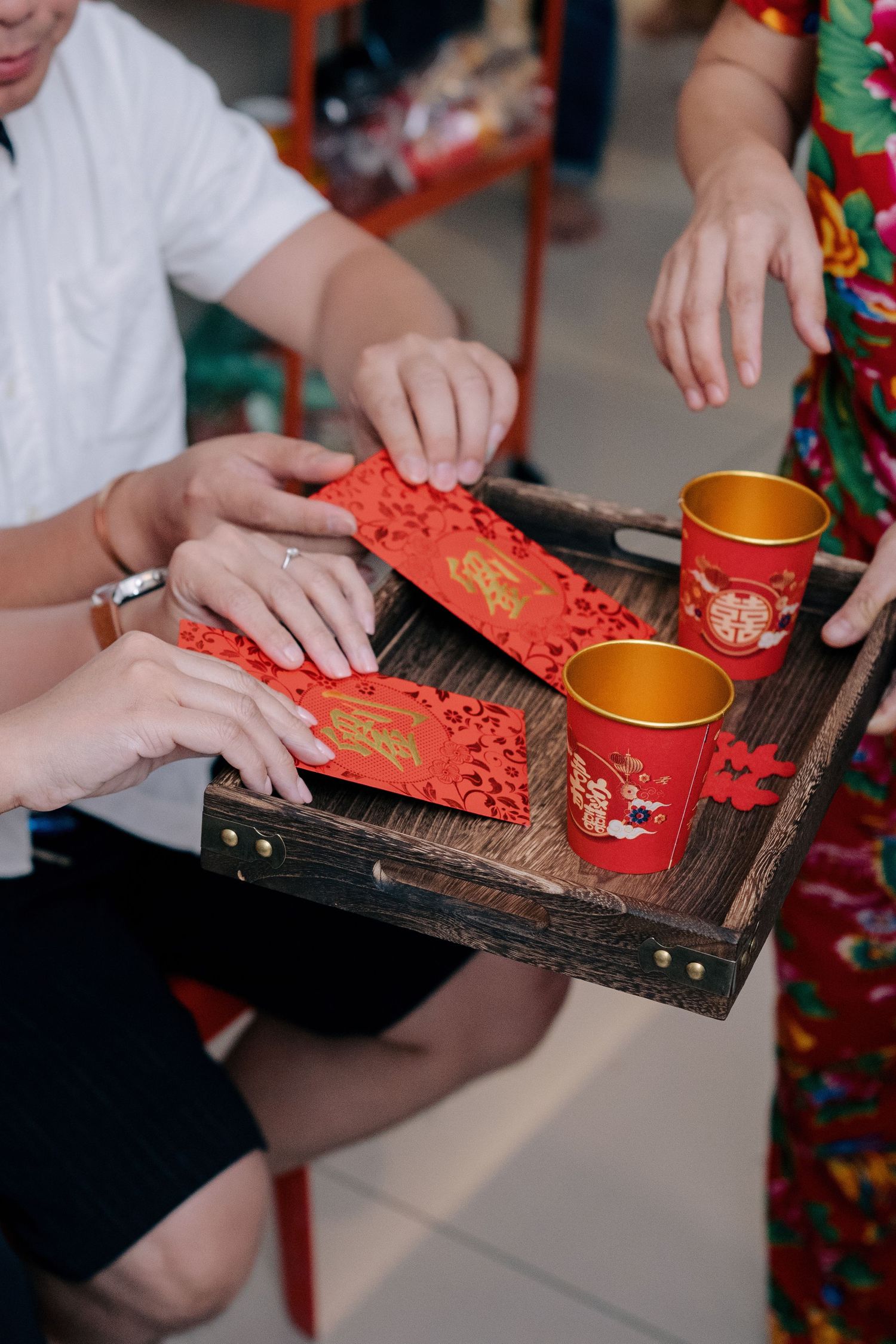 Close-up of the red packets and tea cups used during the Chinese wedding tea ceremony