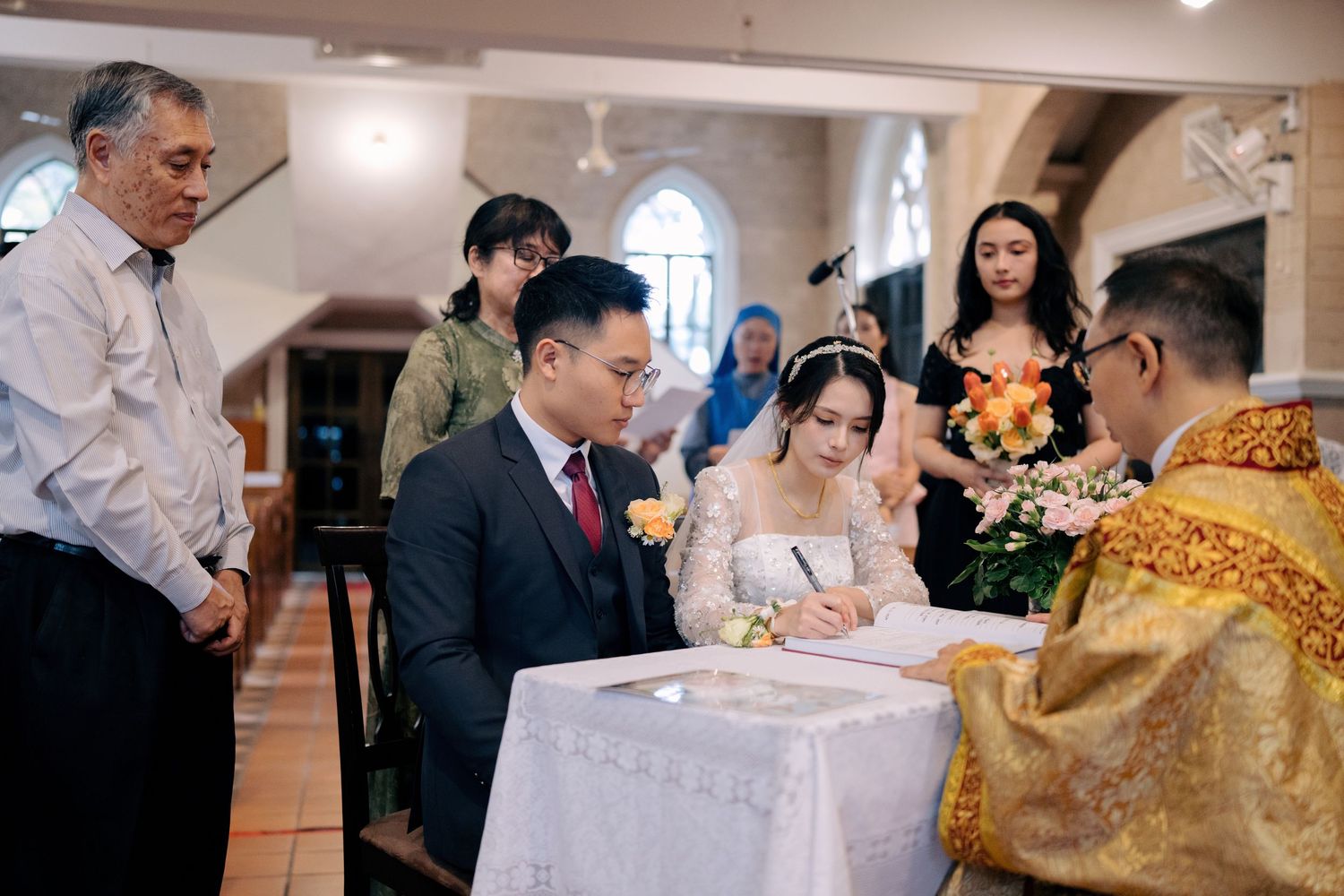 The couple signing the wedding register at the altar after the ceremony