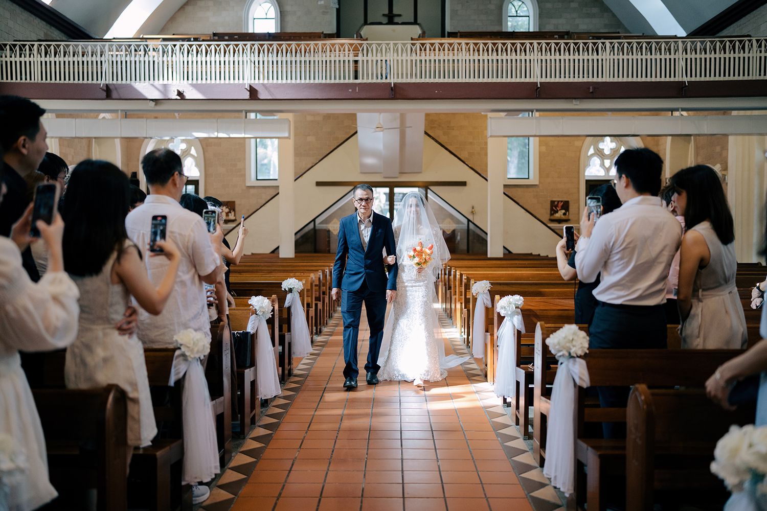 Bride walking down the aisle on her father's arm during a traditional church wedding ceremony