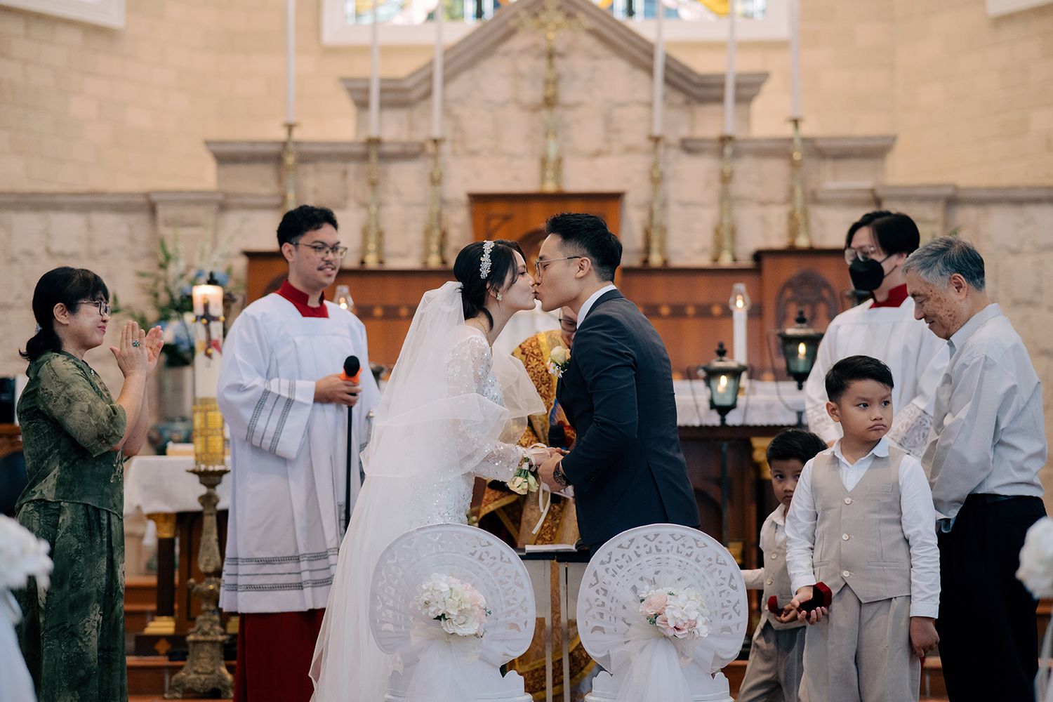 First kiss of the newlyweds during a traditional Catholic church wedding ceremony in Church of the Immaculate Conception Penang