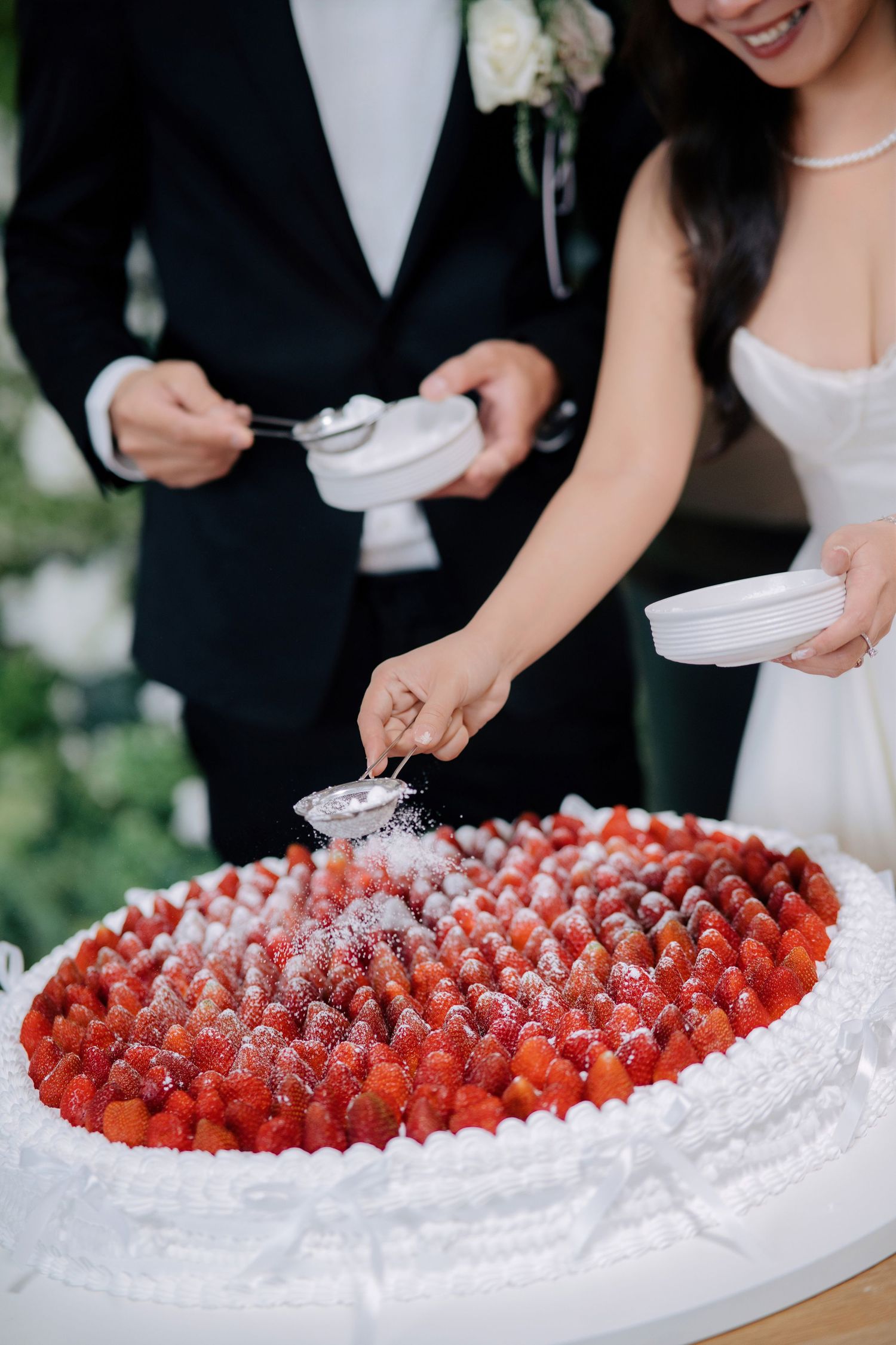 Beautiful wedding cake decorated with fresh strawberries and white frosting.