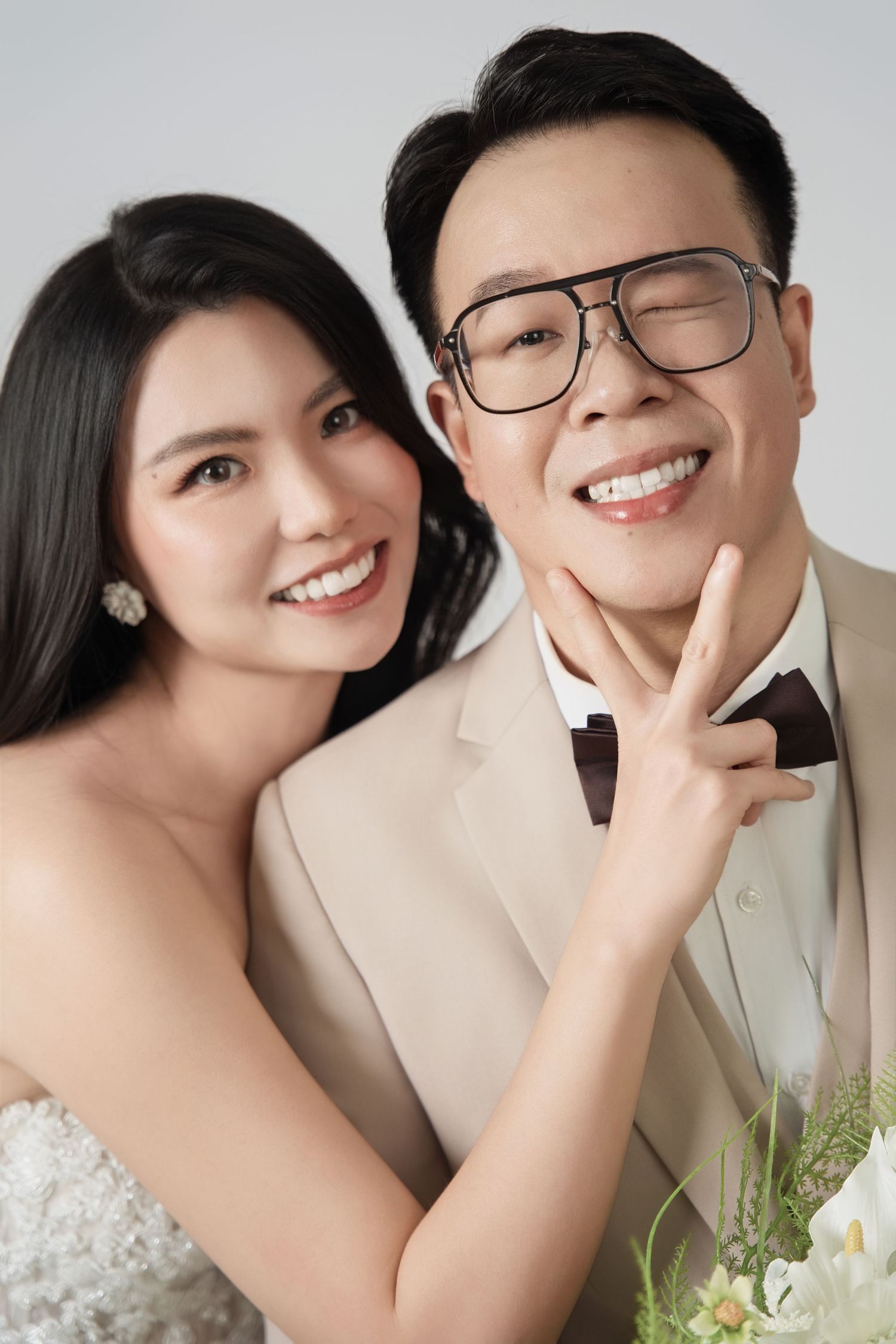 Studio wedding photoshoot with cream and white floral decorations.