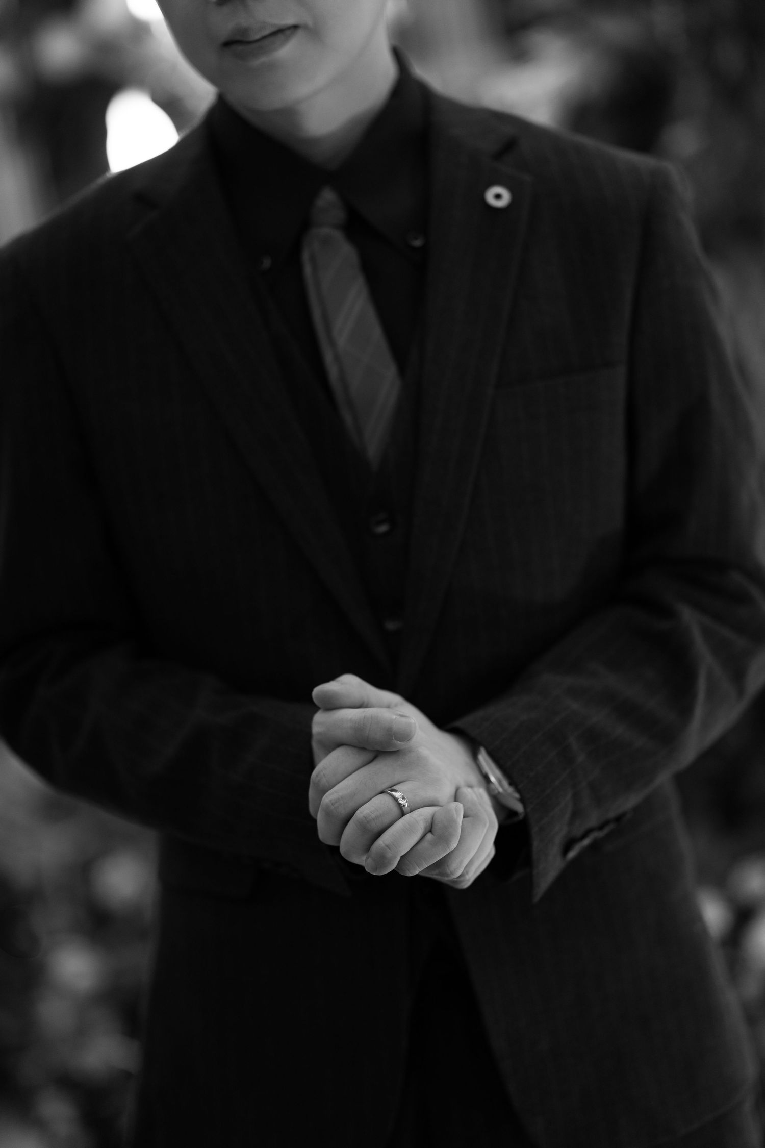 Groom's wedding ring detail and dark pinstripe suit for an elegant evening wedding theme