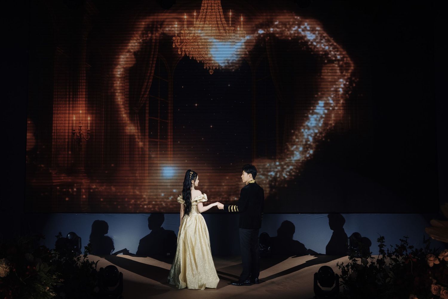 Couple silhouetted against a glowing heart backdrop during a luxury wedding reception