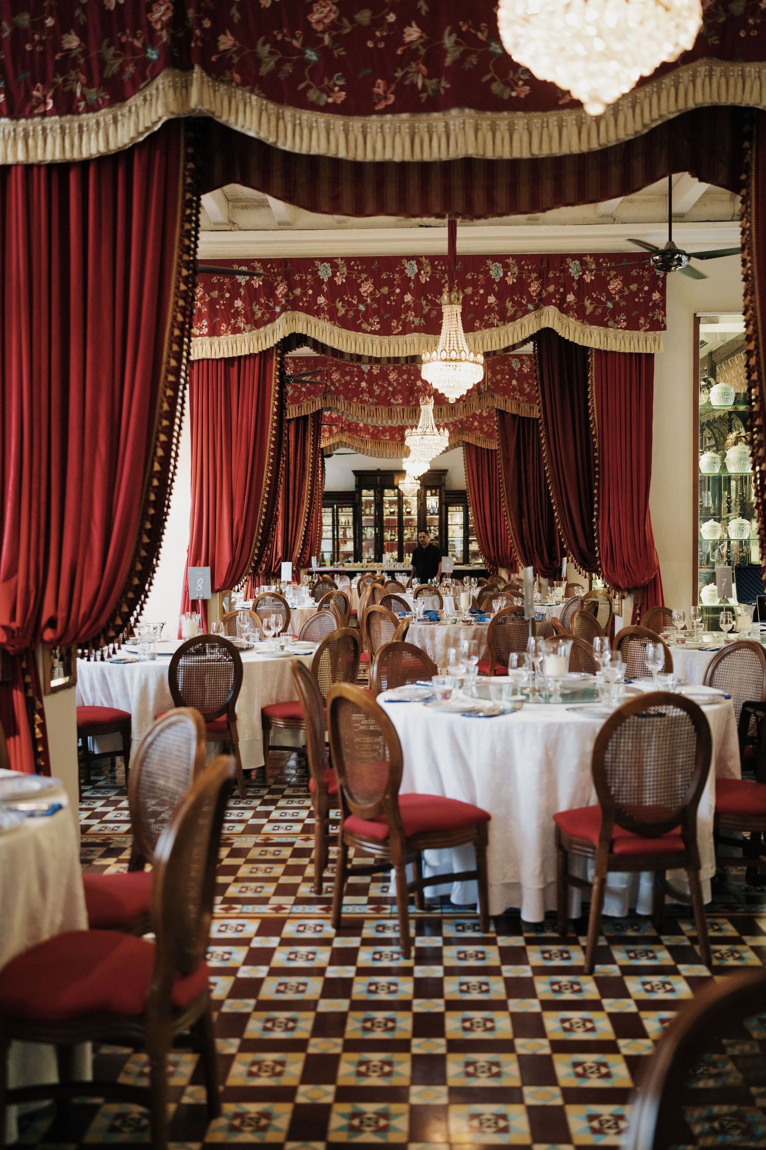 Grand dining hall with red velvet curtains, crystal chandeliers at Seven Terraces prepared for a luxury wedding banquet and recept