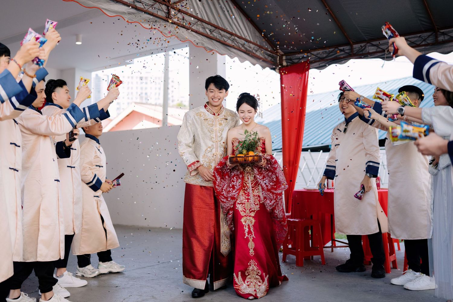 Wedding celebration with guests throwing gold confetti in an indoor venue.
