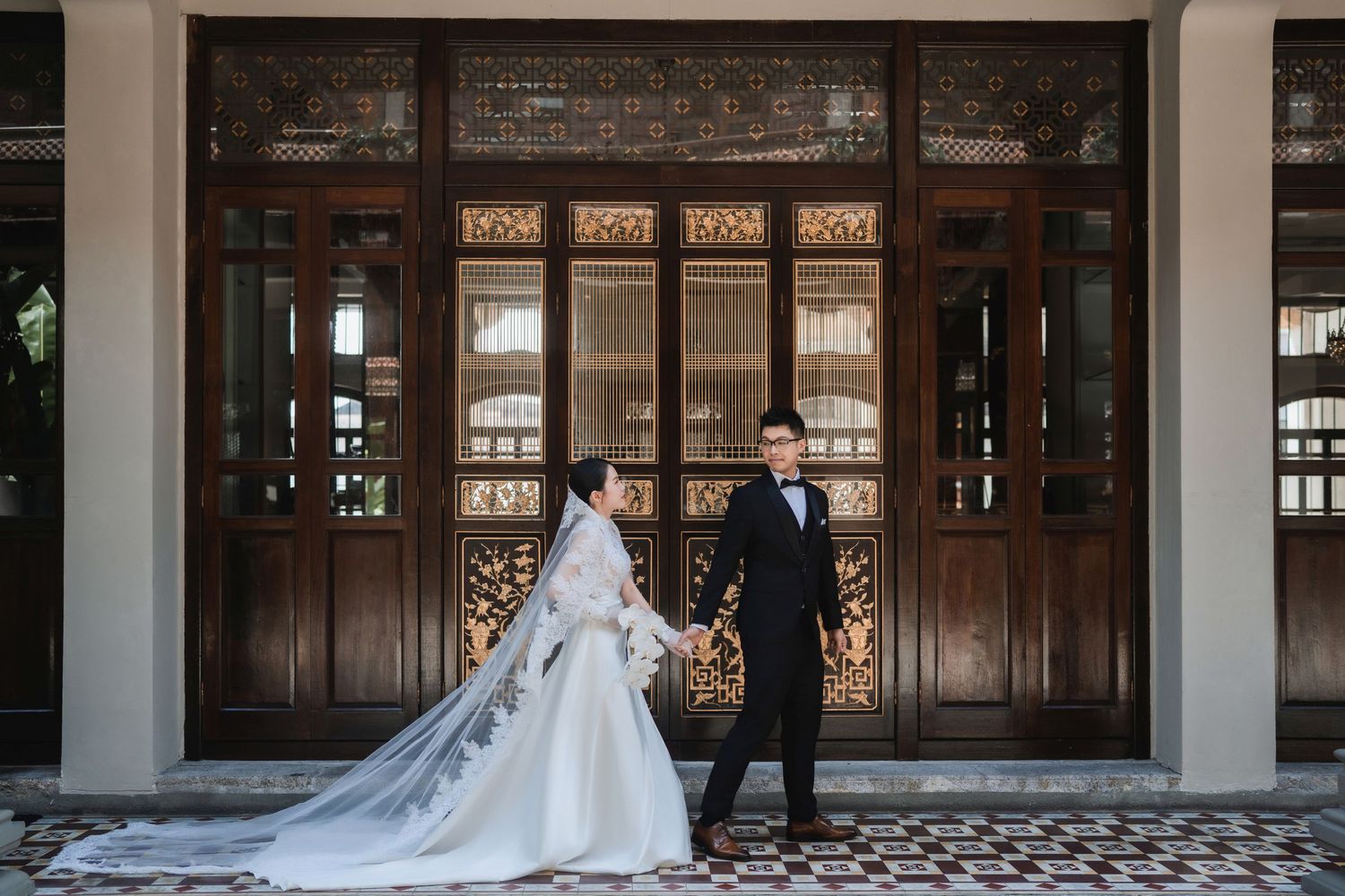 Couple walking through a heritage boutique hotel in Penang, highlighting the traditional architecture and patterned tiling