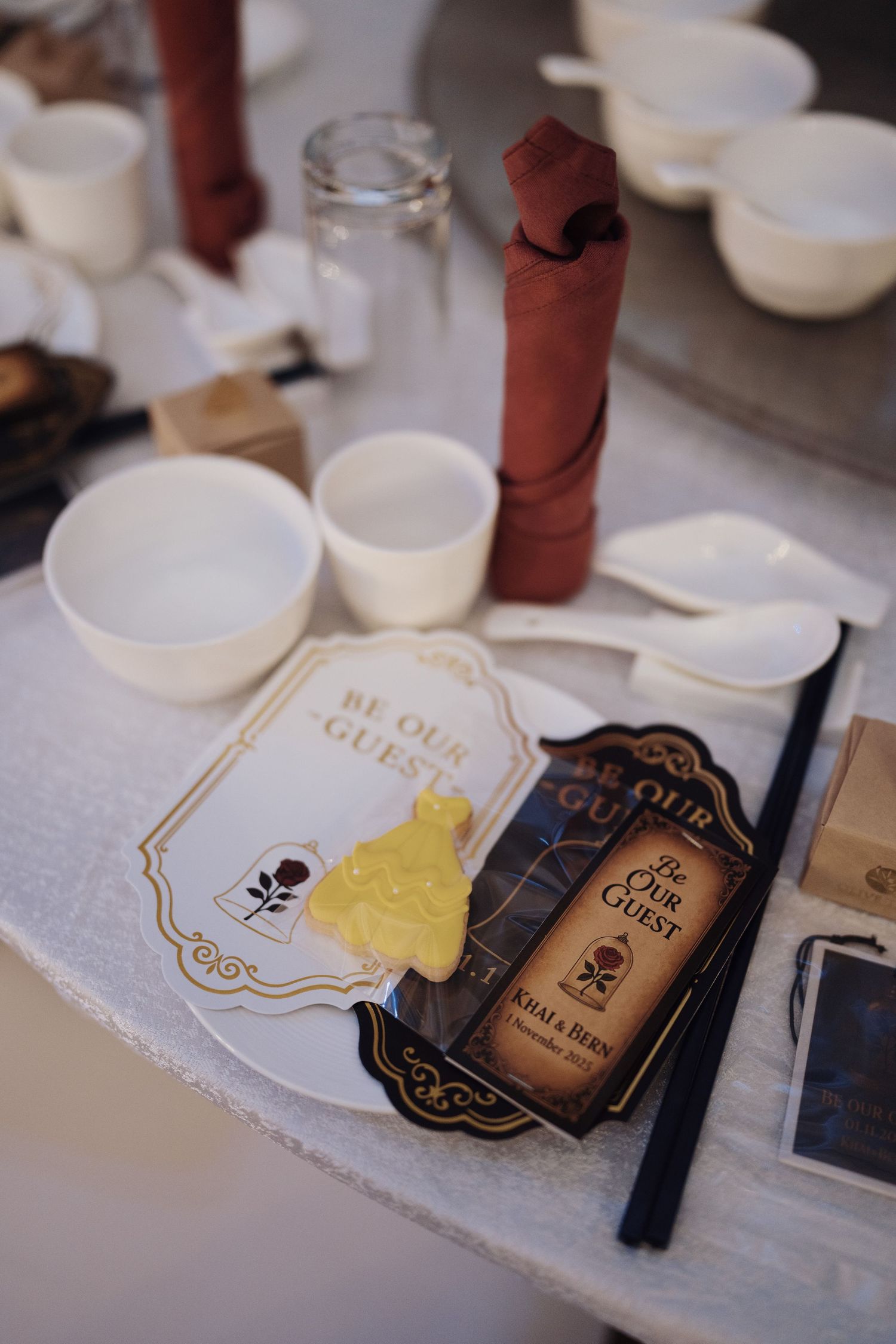 Themed wedding stationery and dress-shaped sugar cookie at a fairytale reception table