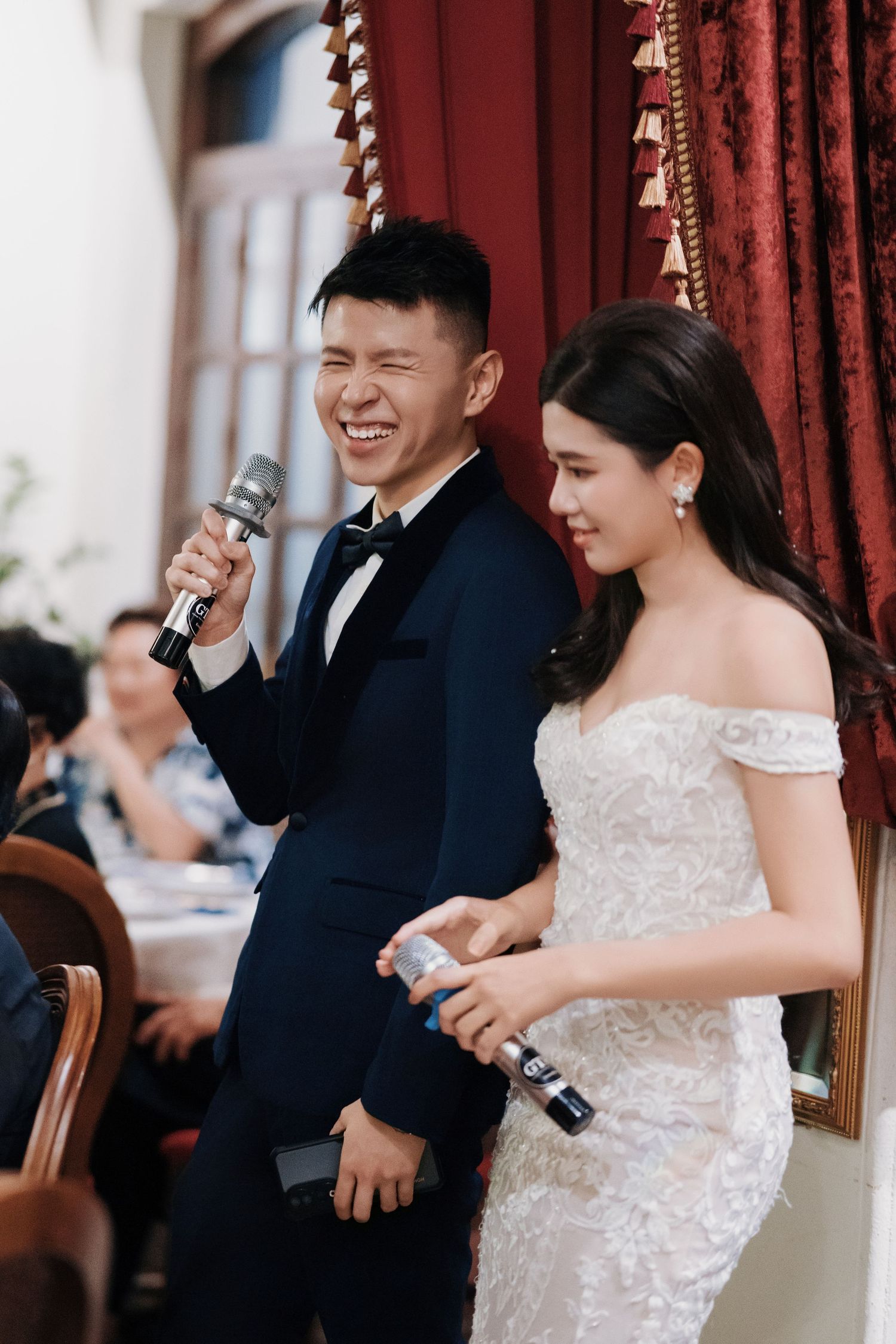 Happy couple laughing during speeches at their Kebaya Dining Room, Seven Terraces Penang heritage hotel wedding reception