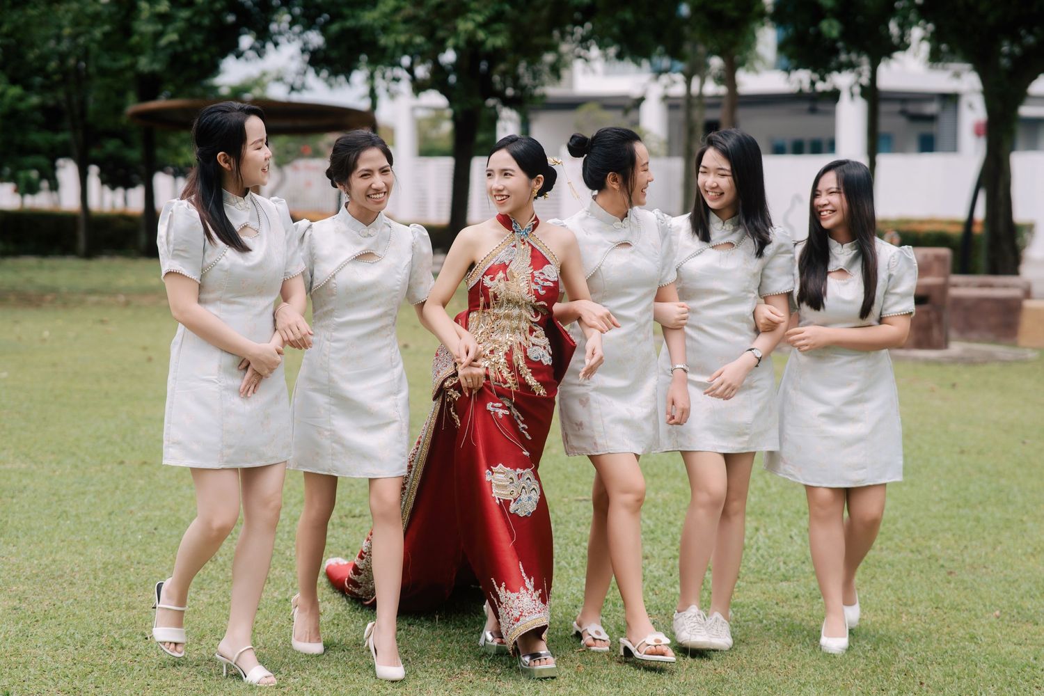 Bride and bridesmaids in traditional Chinese wedding attire walking outdoors