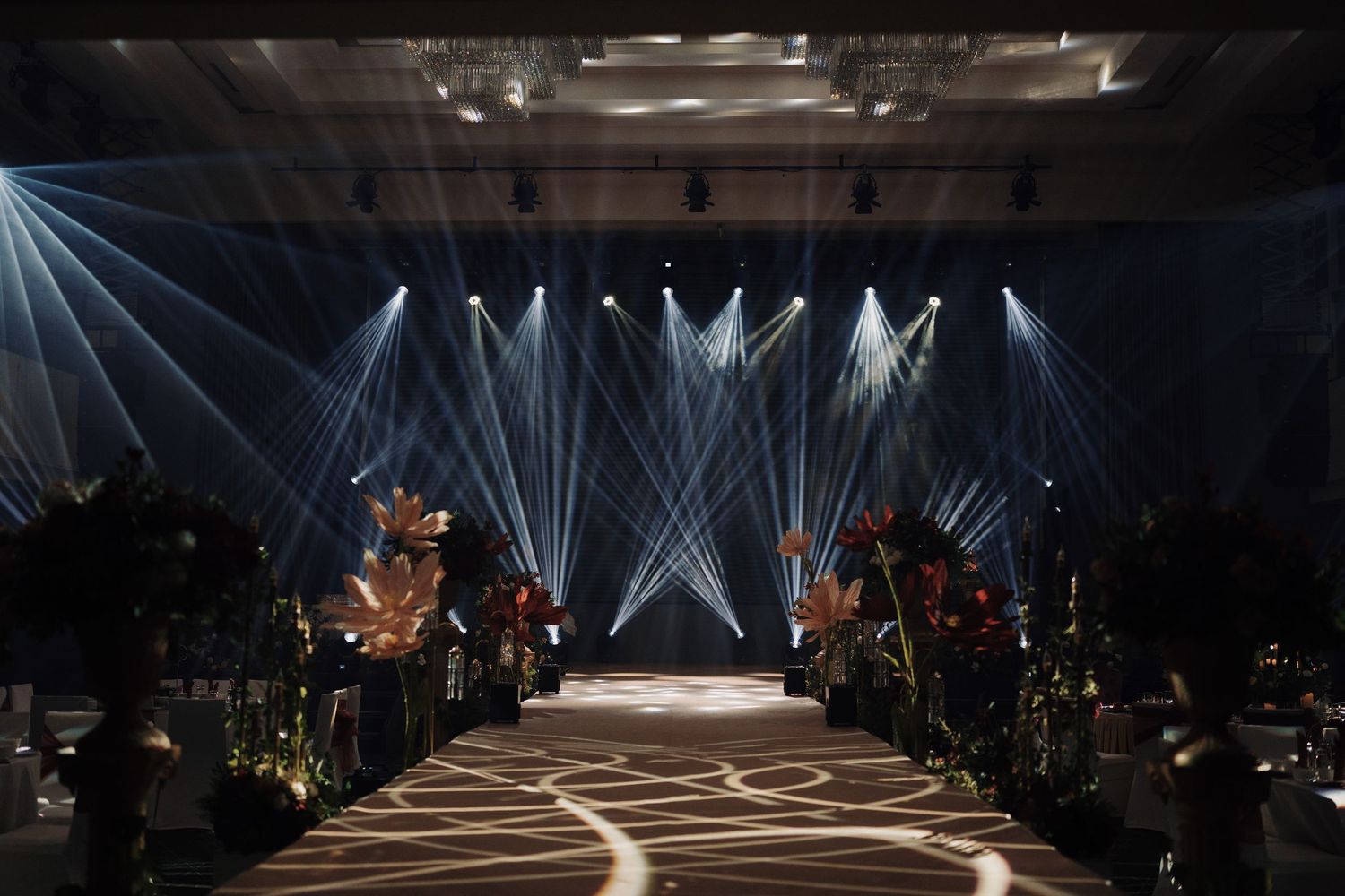 Luxury wedding stage lighting creates a high-end atmosphere for a grand ballroom reception entrance at Olive Tree Hotel