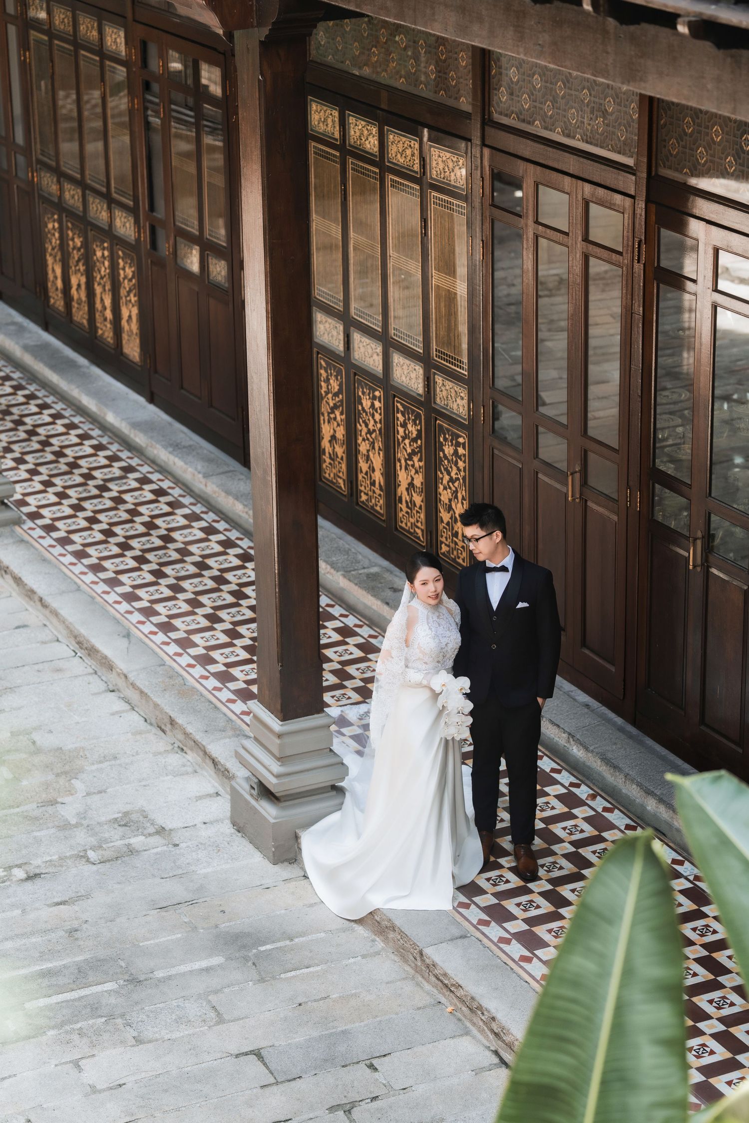 Overhead shot of a couple at a Peranakan architecture wedding venue, capturing the heritage tiles and courtyard layout