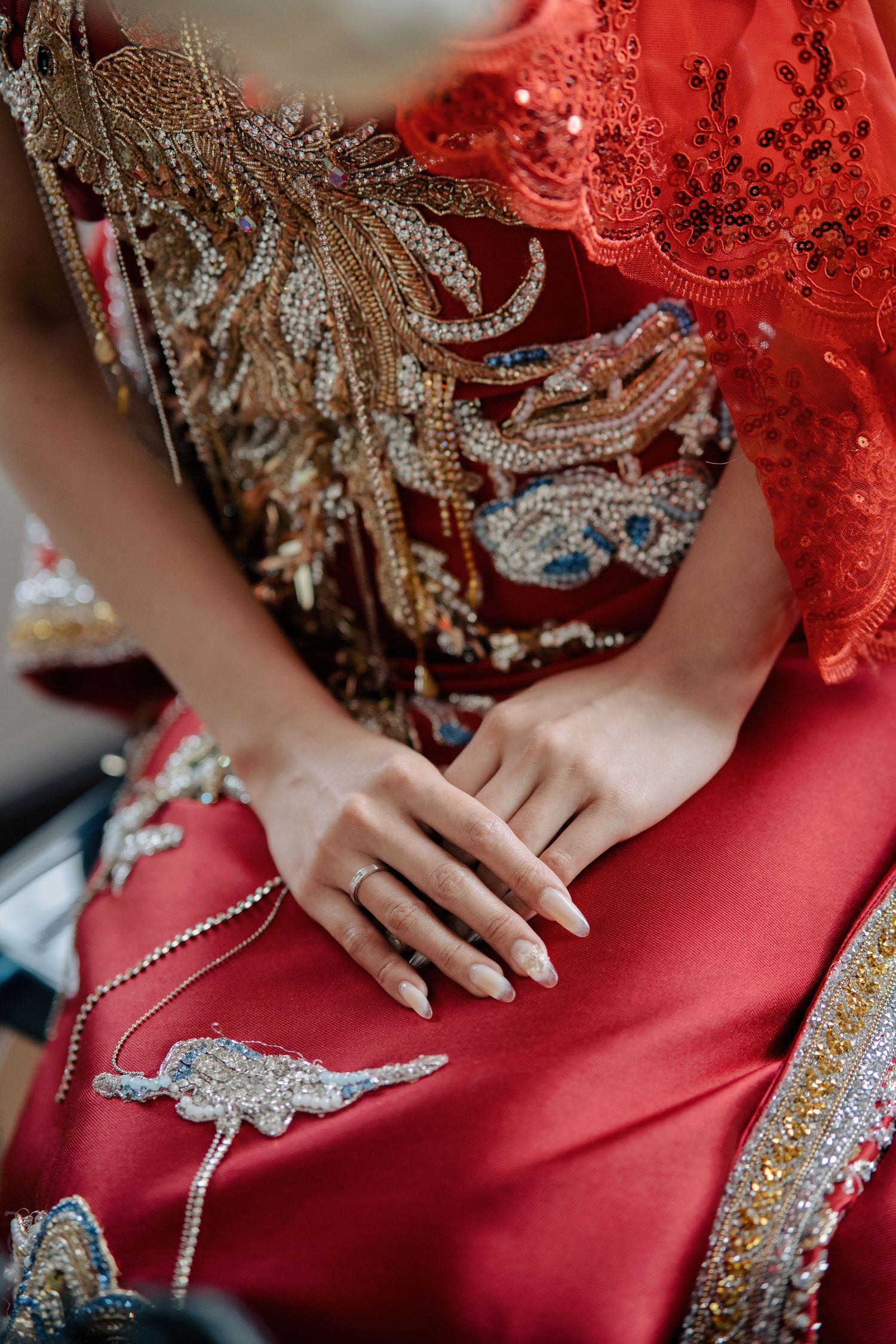 Intricate phoenix embroidery on a bride's red qupao for a traditional Chinese wedding