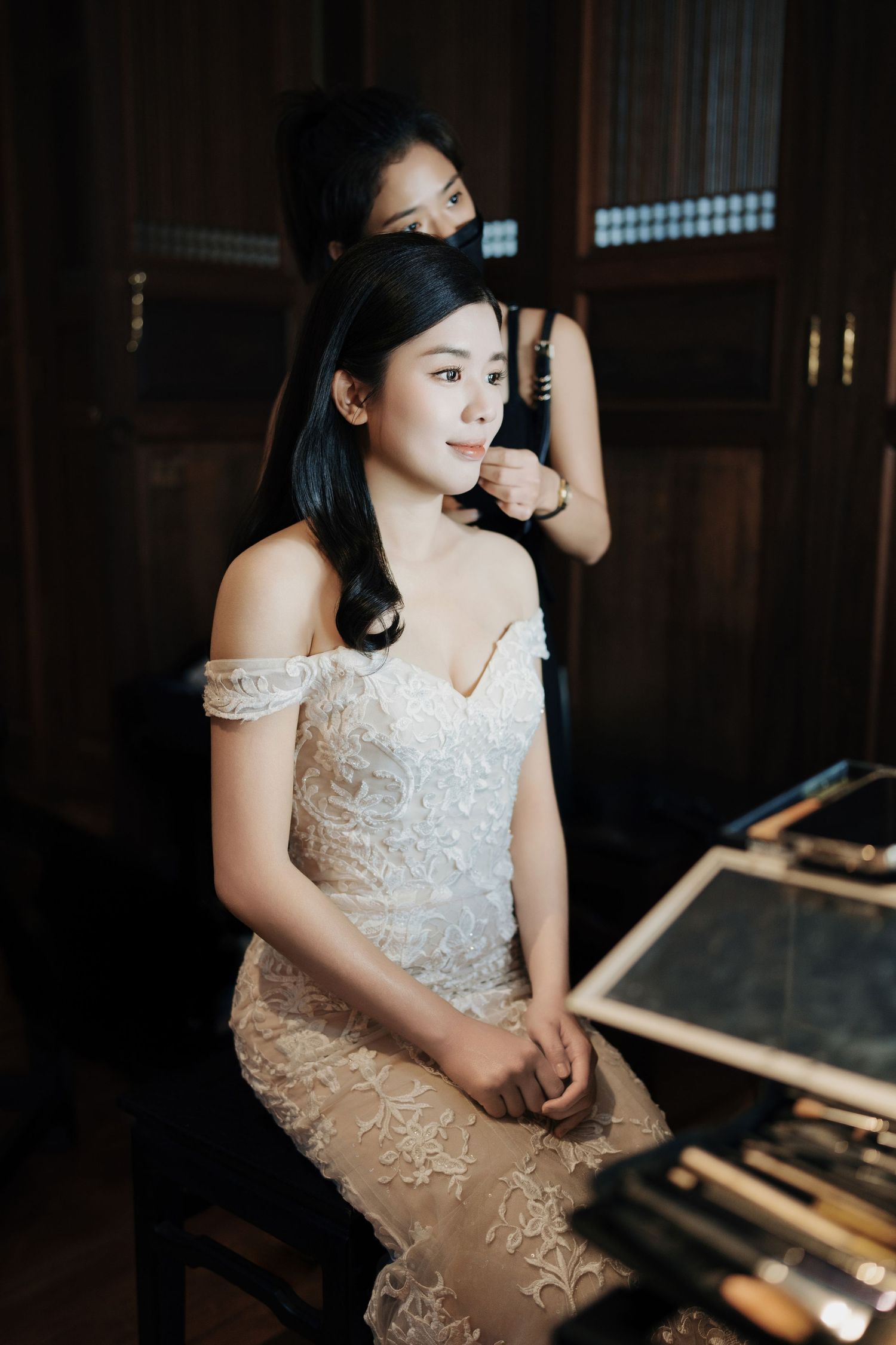 Close-up of a bride in an embroidered lace gown getting her hair styled at Seven Terraces, a luxury wedding venue George Town