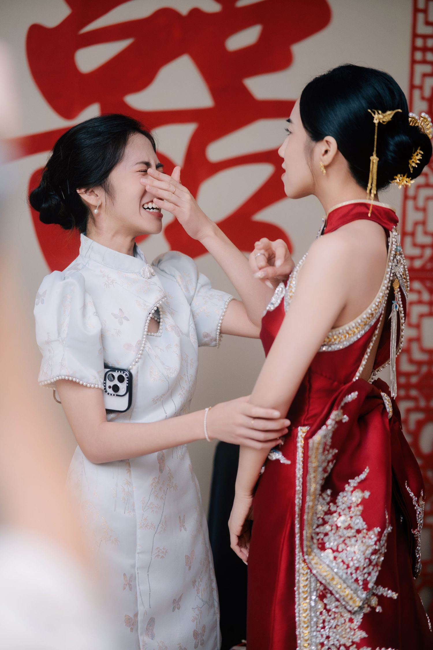 Emotional moment between a bride and her bridesmaid during a Traditional Chinese Wedding