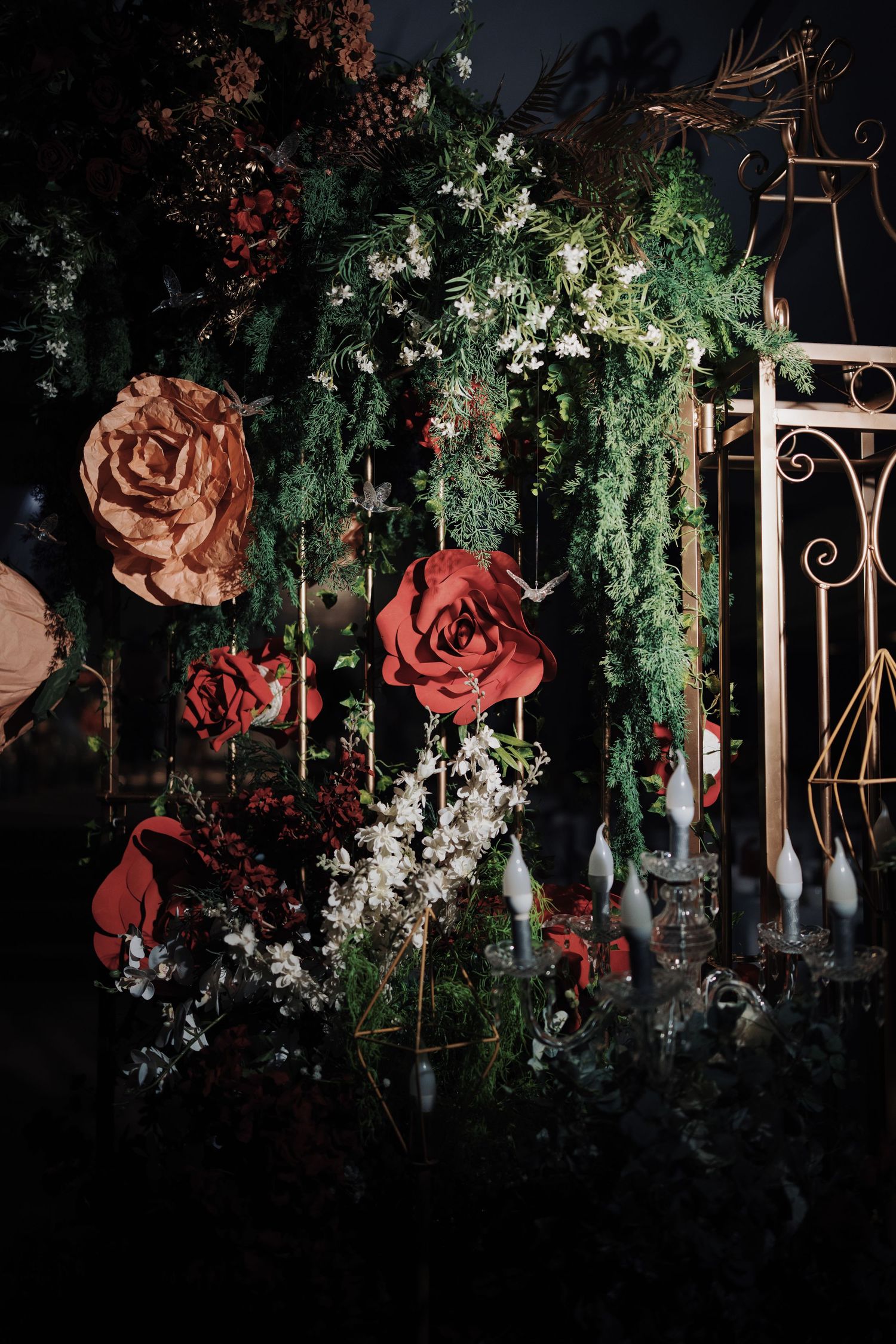 Close-up of giant rose decorations and greenery for a Beauty and the Beast wedding theme