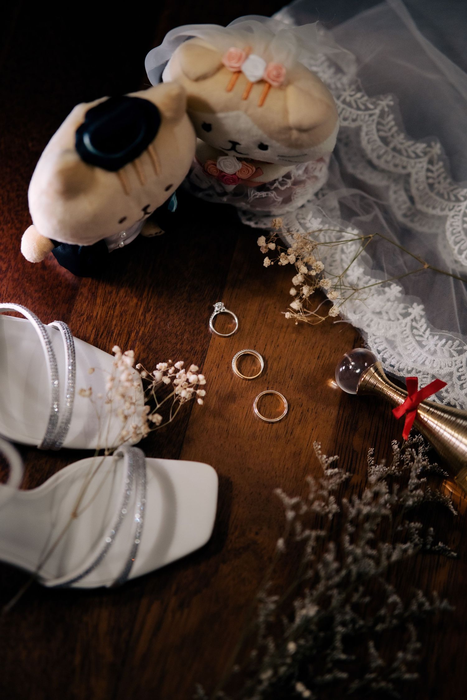 Wedding rings and delicate lace details arranged on a dark wooden surface at Eastern & Oriental Hotel (E&O).