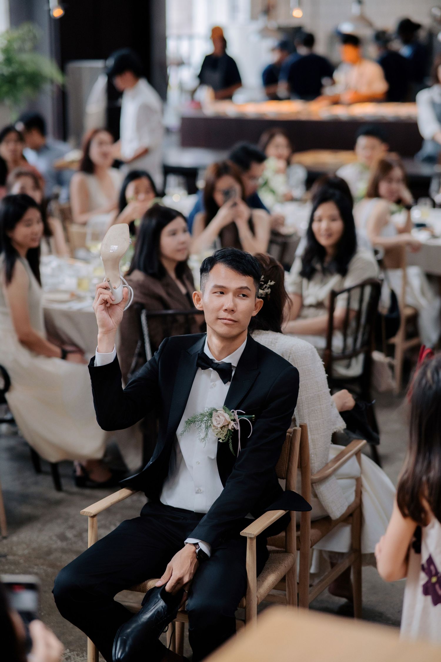 Groom holding up a bride's shoe during the wedding shoe game at Peninsula House