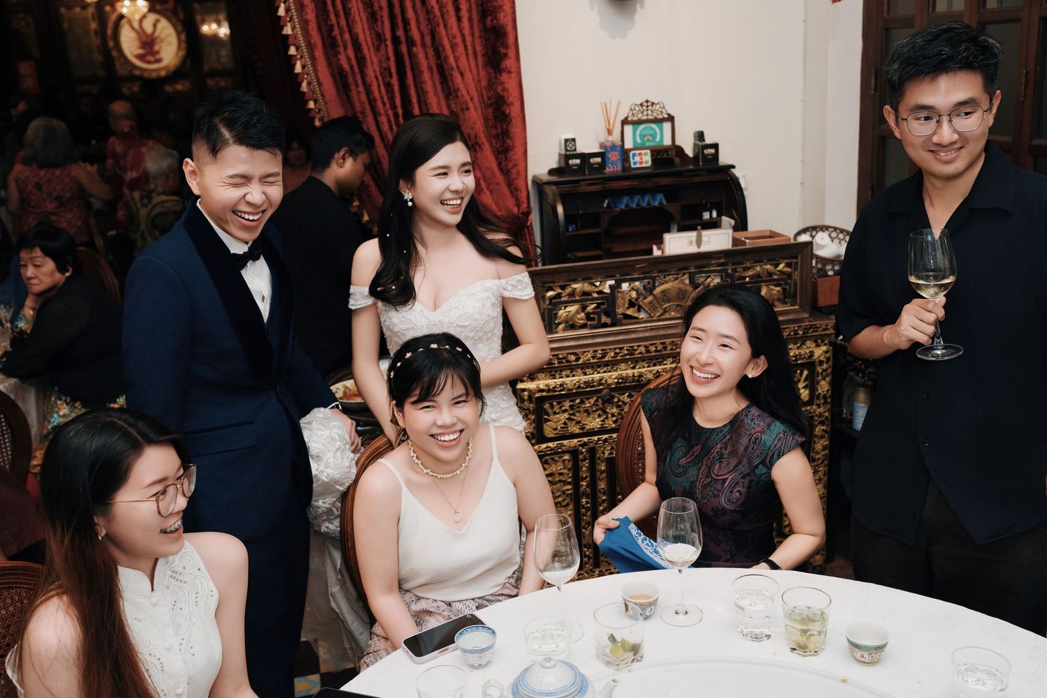 A cheerful group photo of the bride, groom, and friends at a Kebaya Dining Room