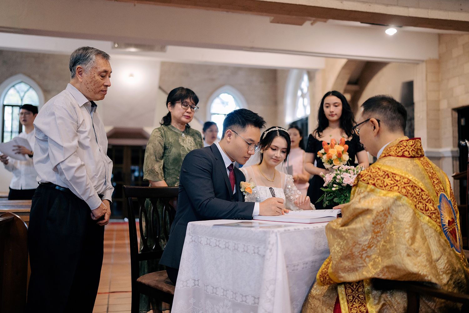 Newlyweds signing the official marriage certificate during their church ceremony