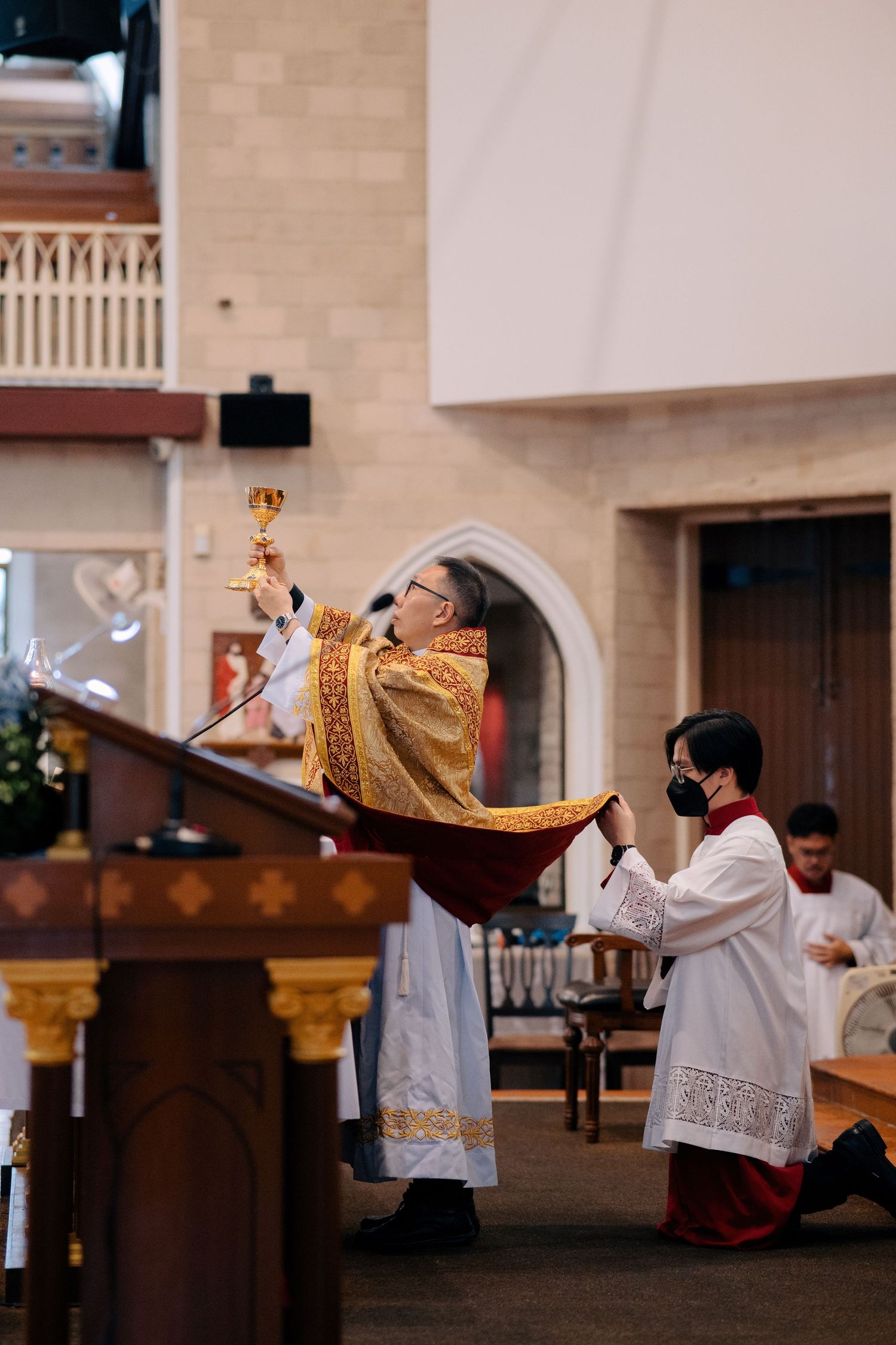 Priest performing the Consecration with a golden chalice during a wedding liturgy