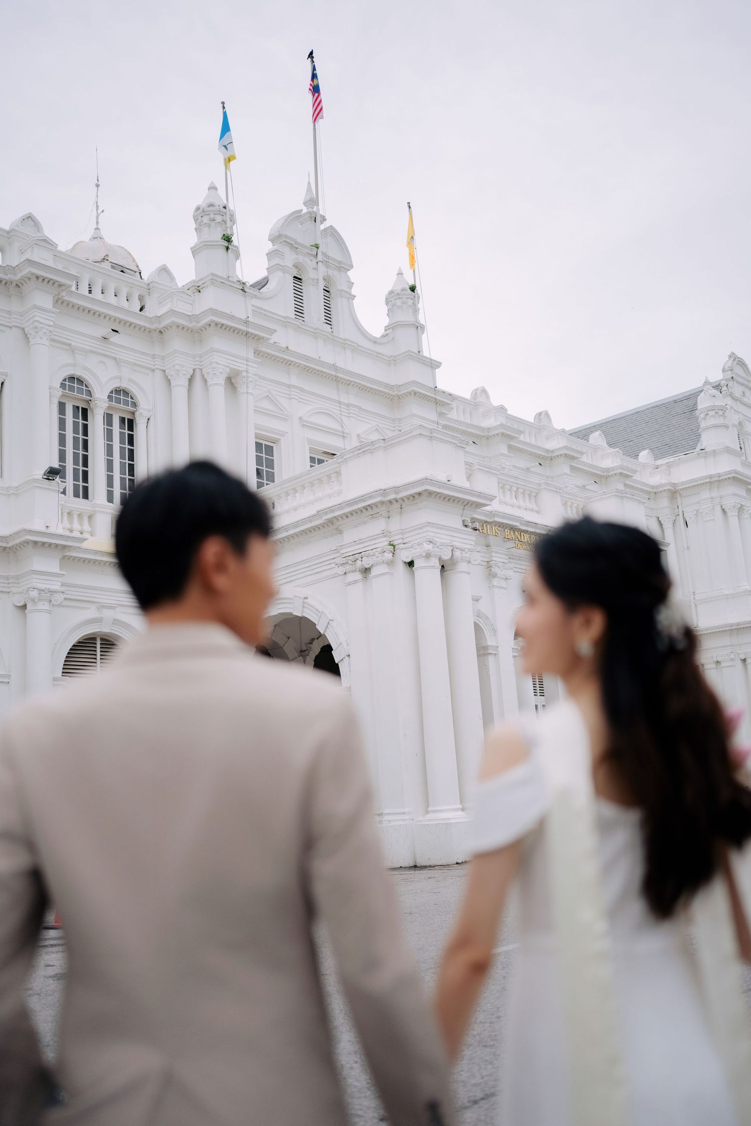 Elegant white colonial building serves as majestic backdrop for wedding photography.