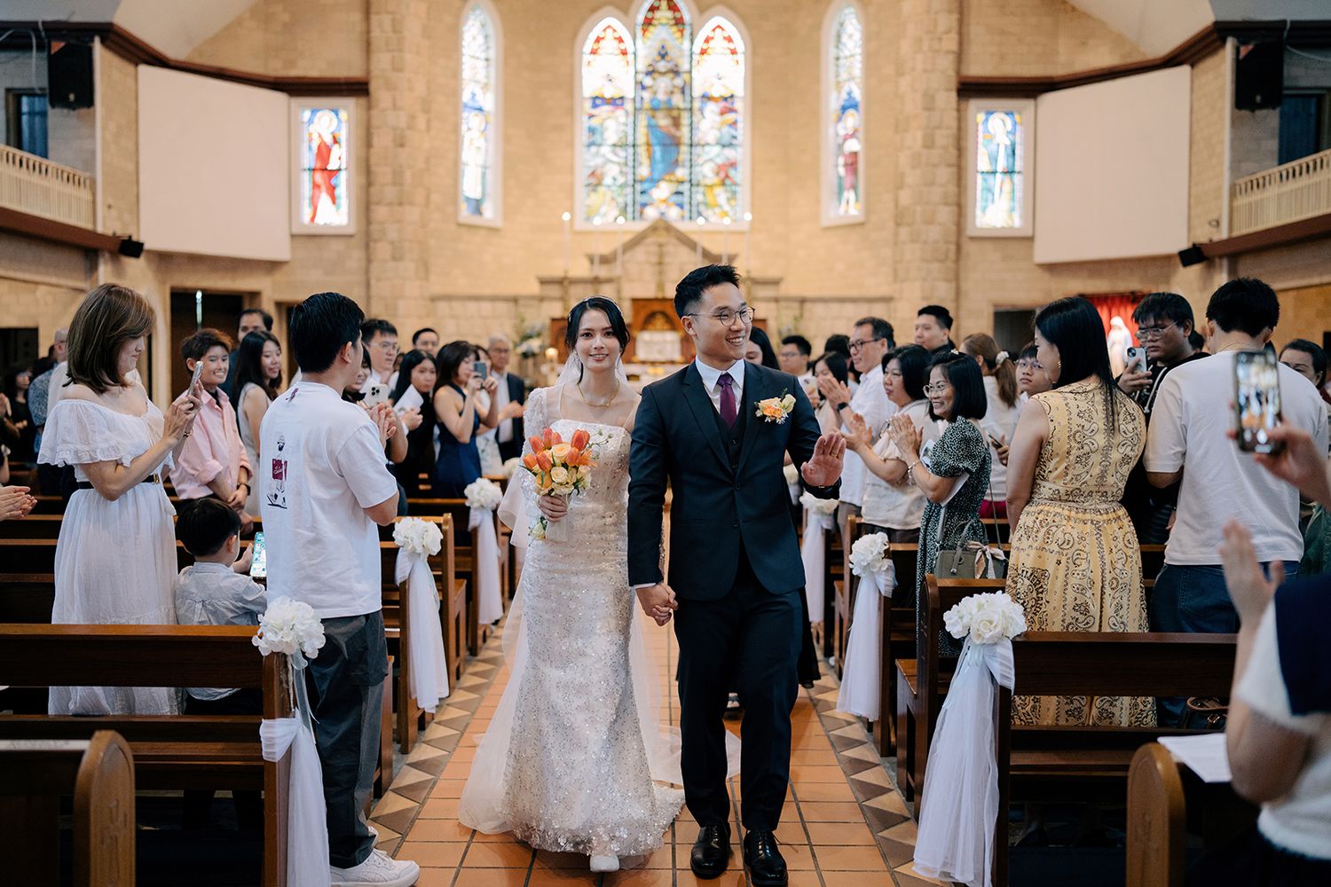 Wedding photography of a bride and groom during the recessional in a grand Catholic church