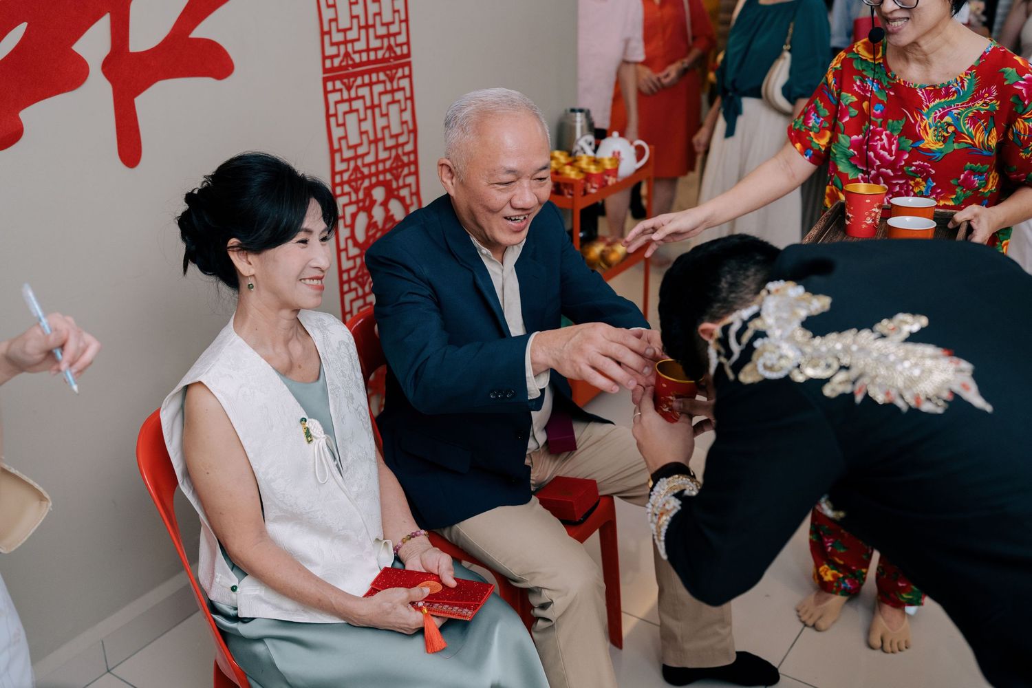 A groom bows and serves tea to his elders as part of a traditional Chinese wedding ritual