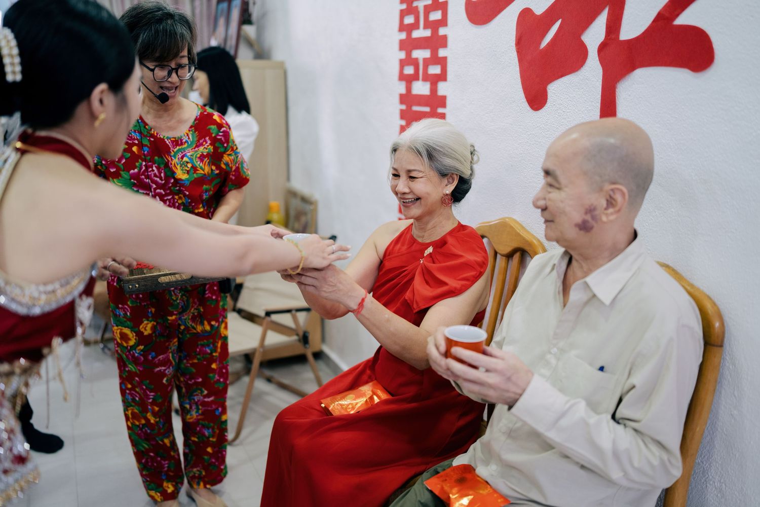 Bride serving tea to her parents-in-law as part of traditional Chinese wedding customs