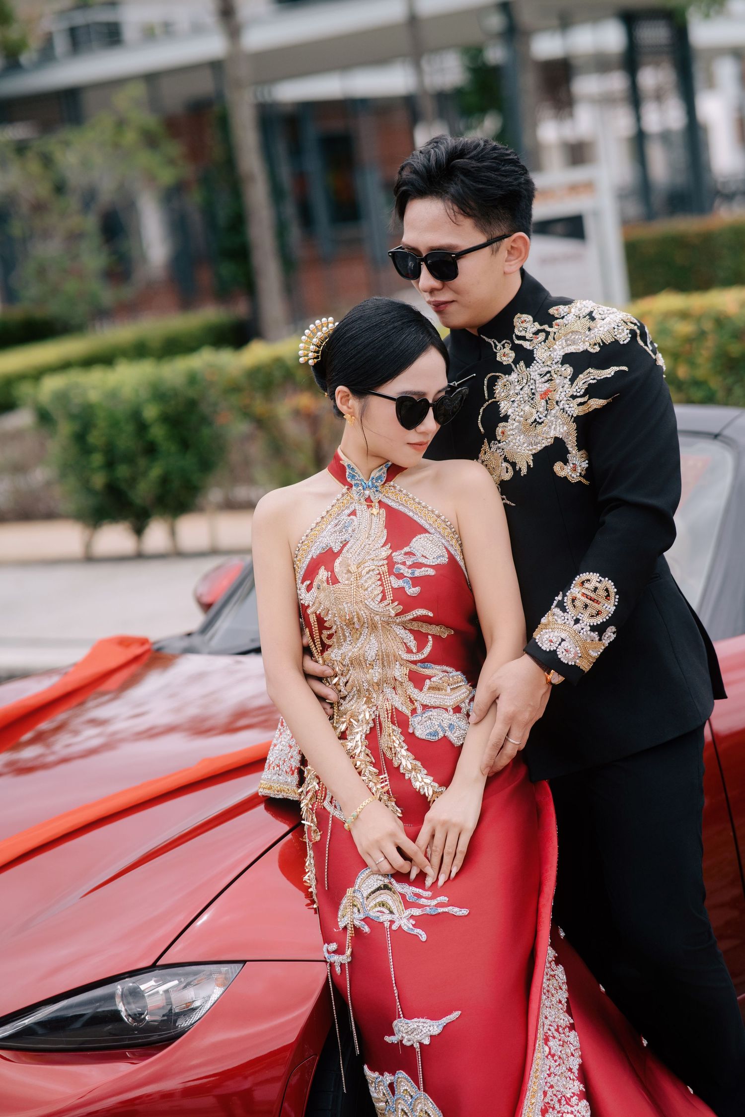 Stylish Chinese wedding couple in embroidered outfits and heart-shaped sunglasses