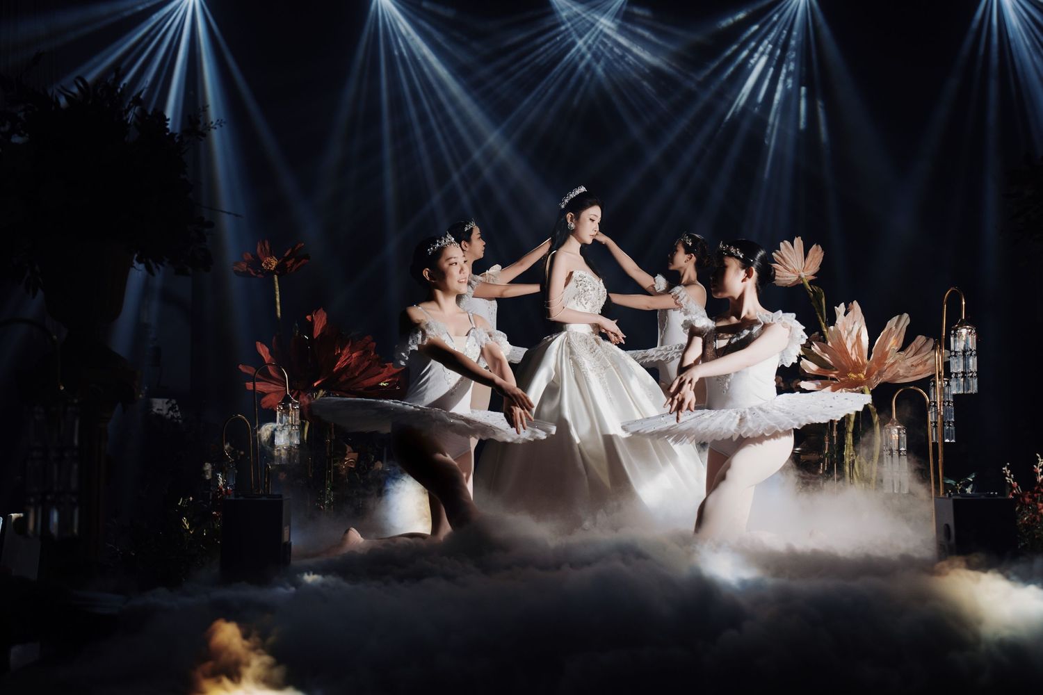 Theatrical wedding performance with multiple spotlights and fog effects on a dark stage.