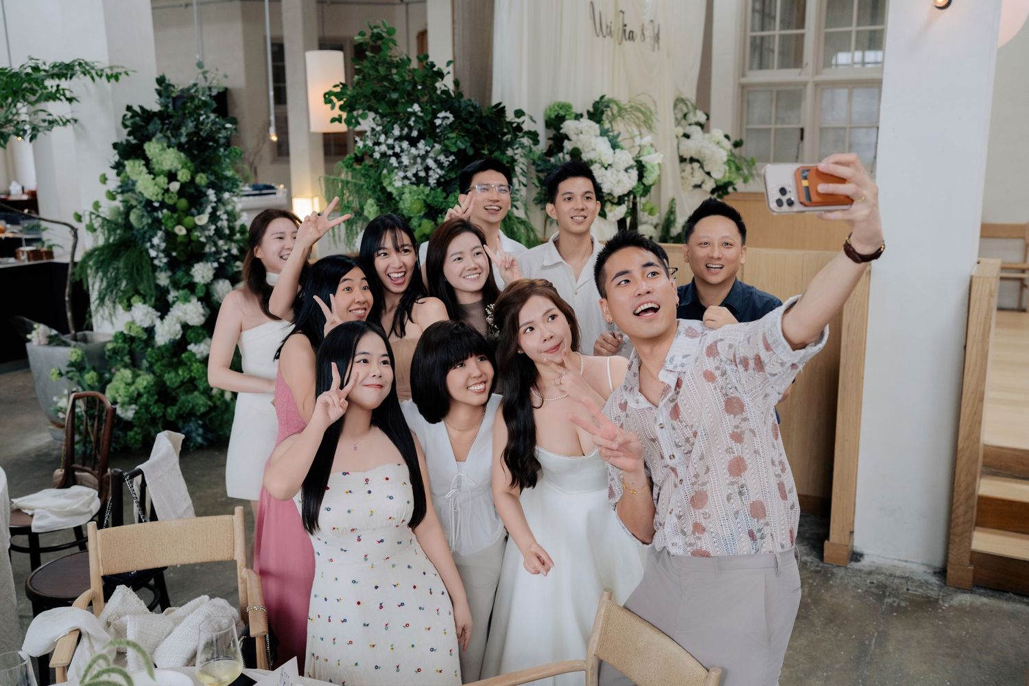 Wedding guests capture a selfie, showcasing Peninsula House Penang wedding photography spots and florals