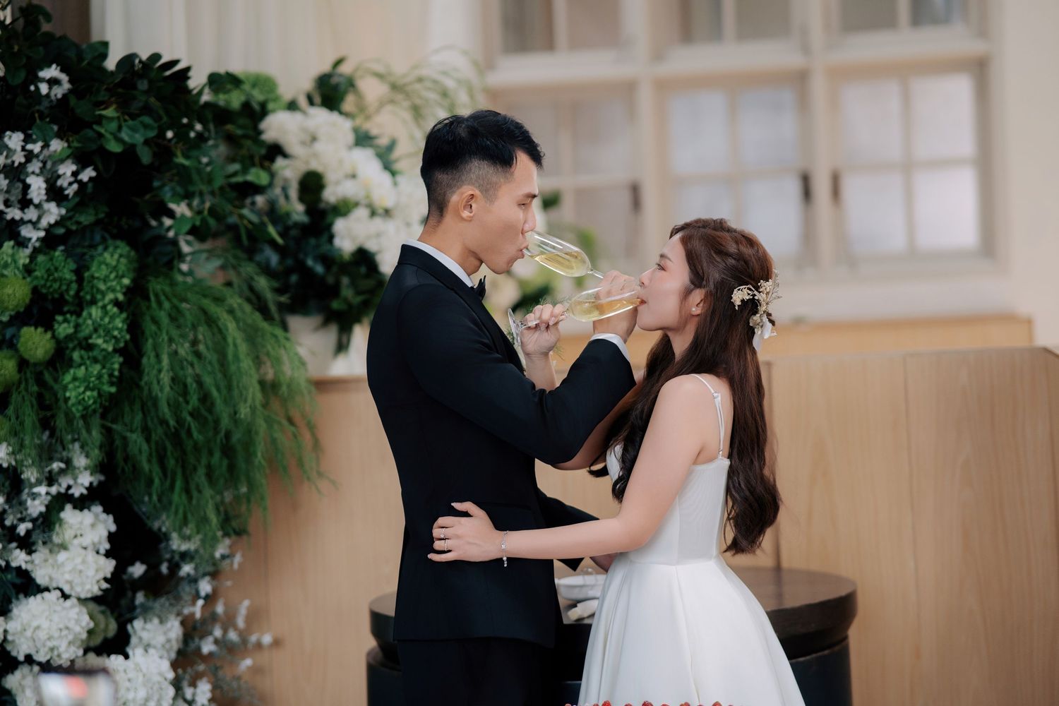 Bride and groom interlock arms for a celebratory toast at Peninsula House Penang