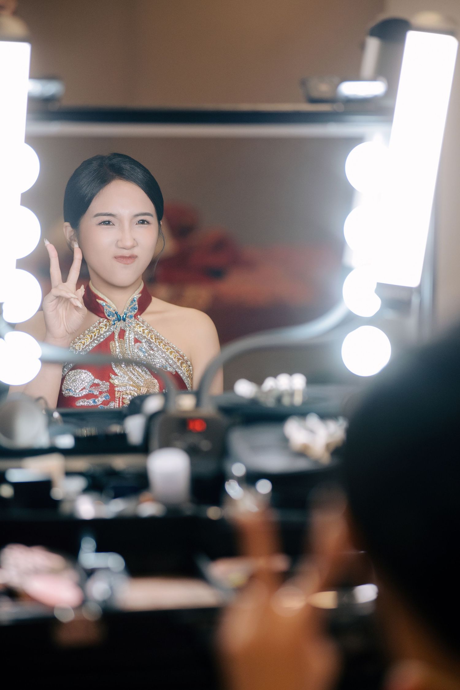 Candid wedding photographer in Penang captures a bride's playful personality in the mirror during makeup