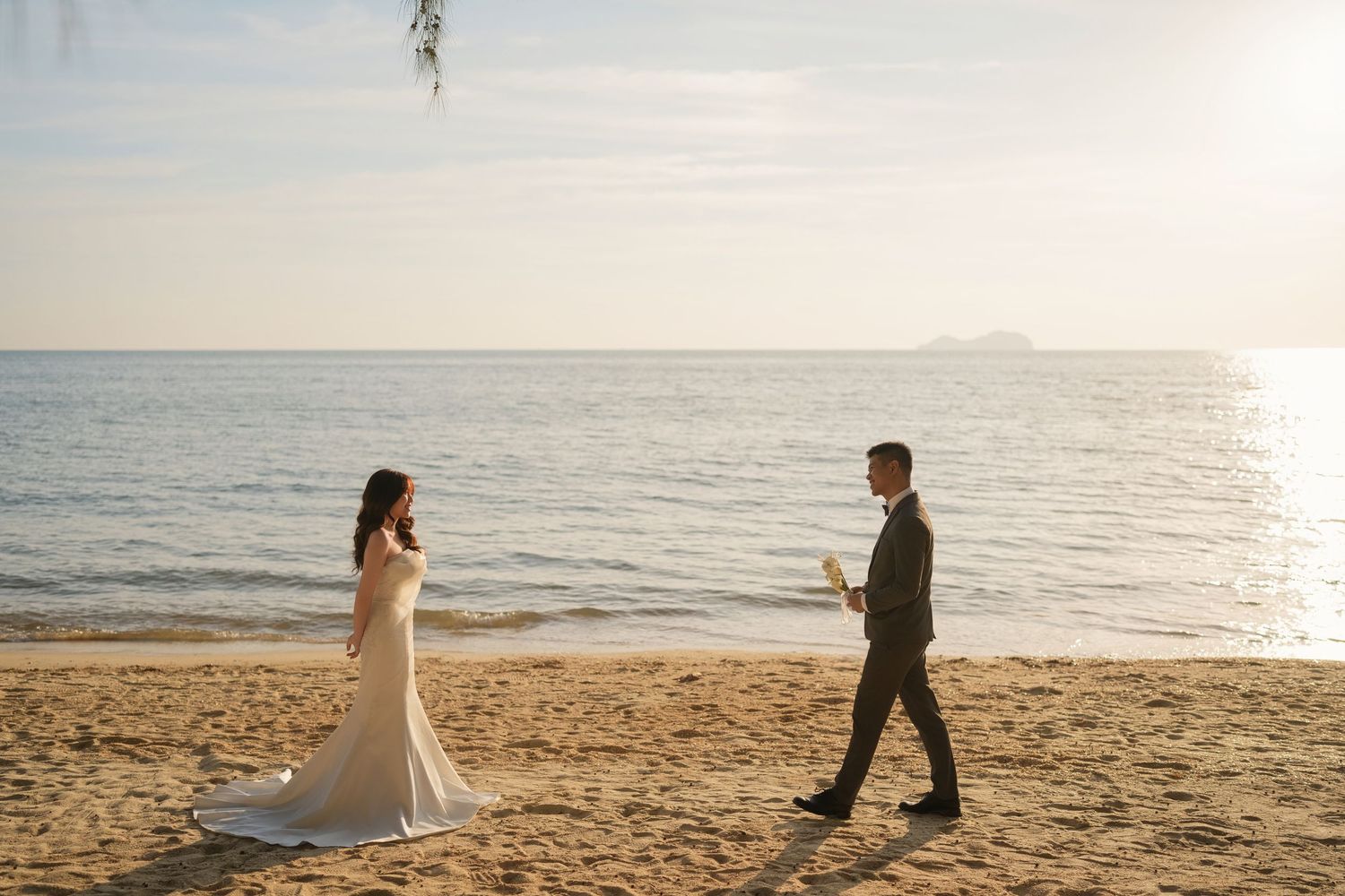 Groom walking to meet his bride on Teluk Bayu Beach, capturing a candid pre-wedding moment by the ocean