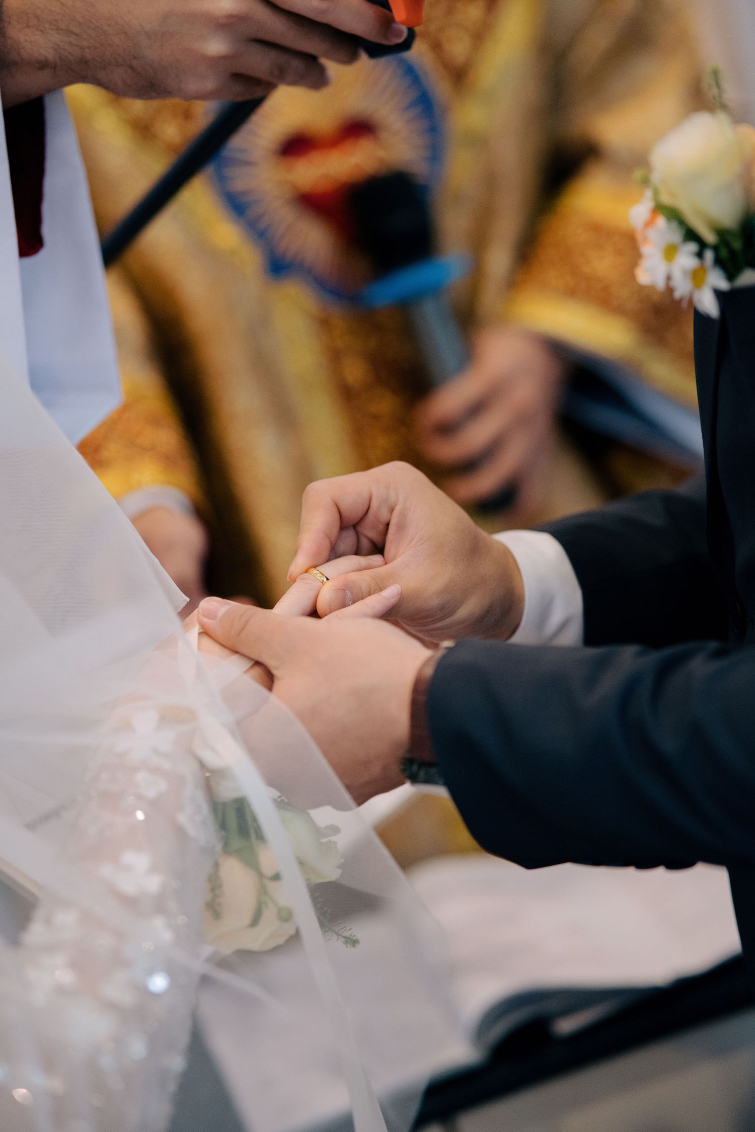 Close-up of the wedding ring exchange during a Catholic church wedding ceremony
