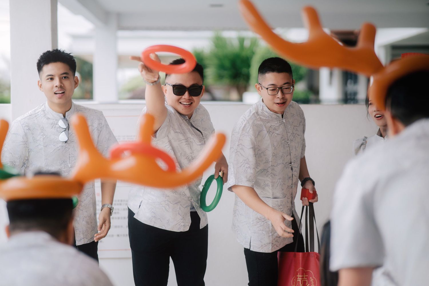 Fun ring toss challenge during traditional Chinese wedding gate-crashing games for the groom
