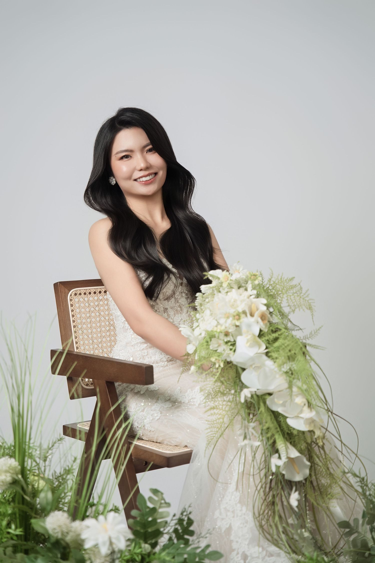 Studio portrait with white floral arrangements and natural decor elements.