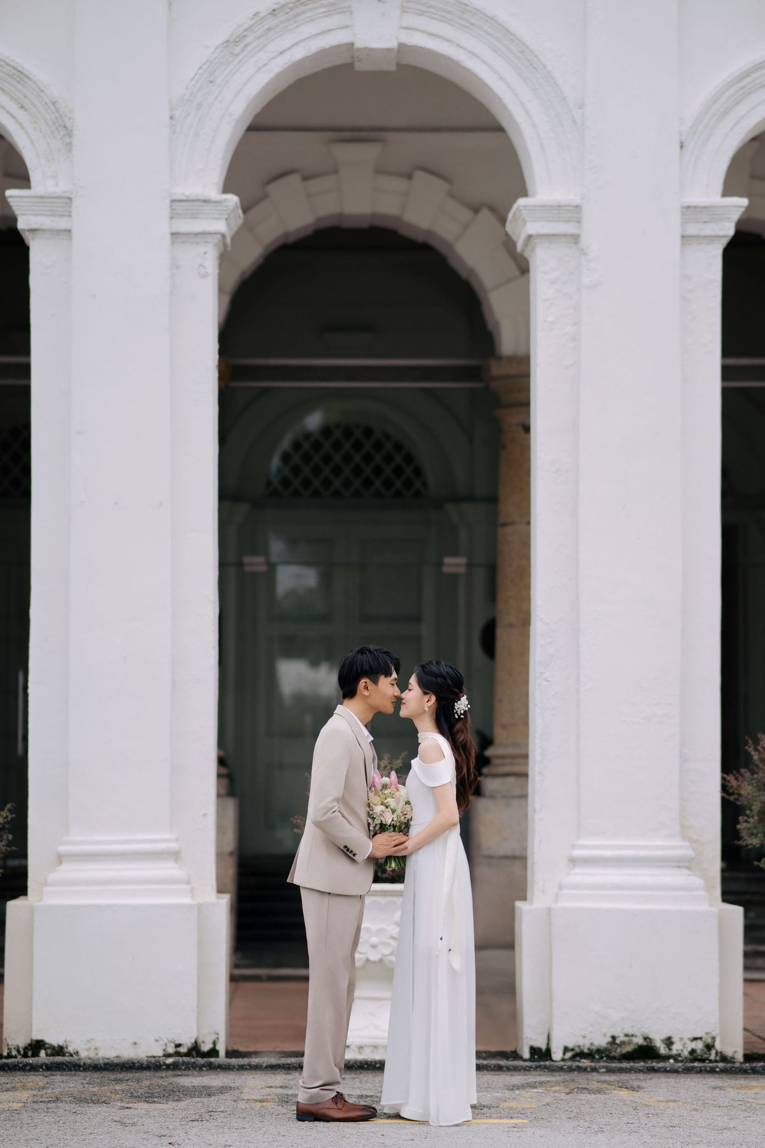 Classical white colonnade architecture with arched walkways and pillars.
