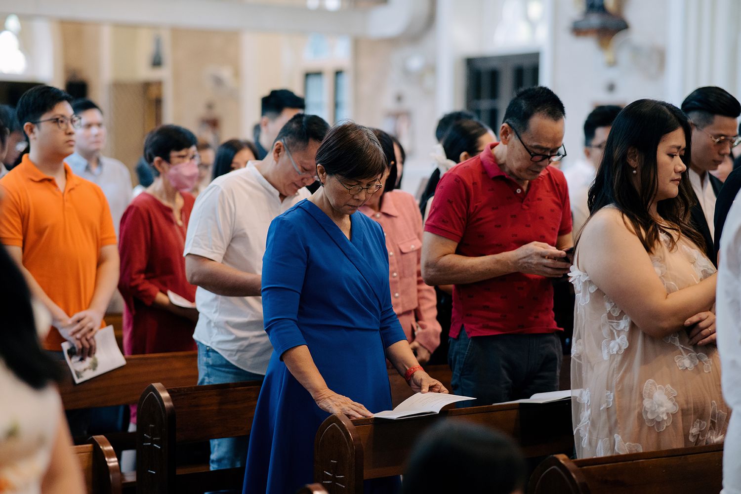 Guests following the liturgy and hymns during a traditional church wedding ceremony