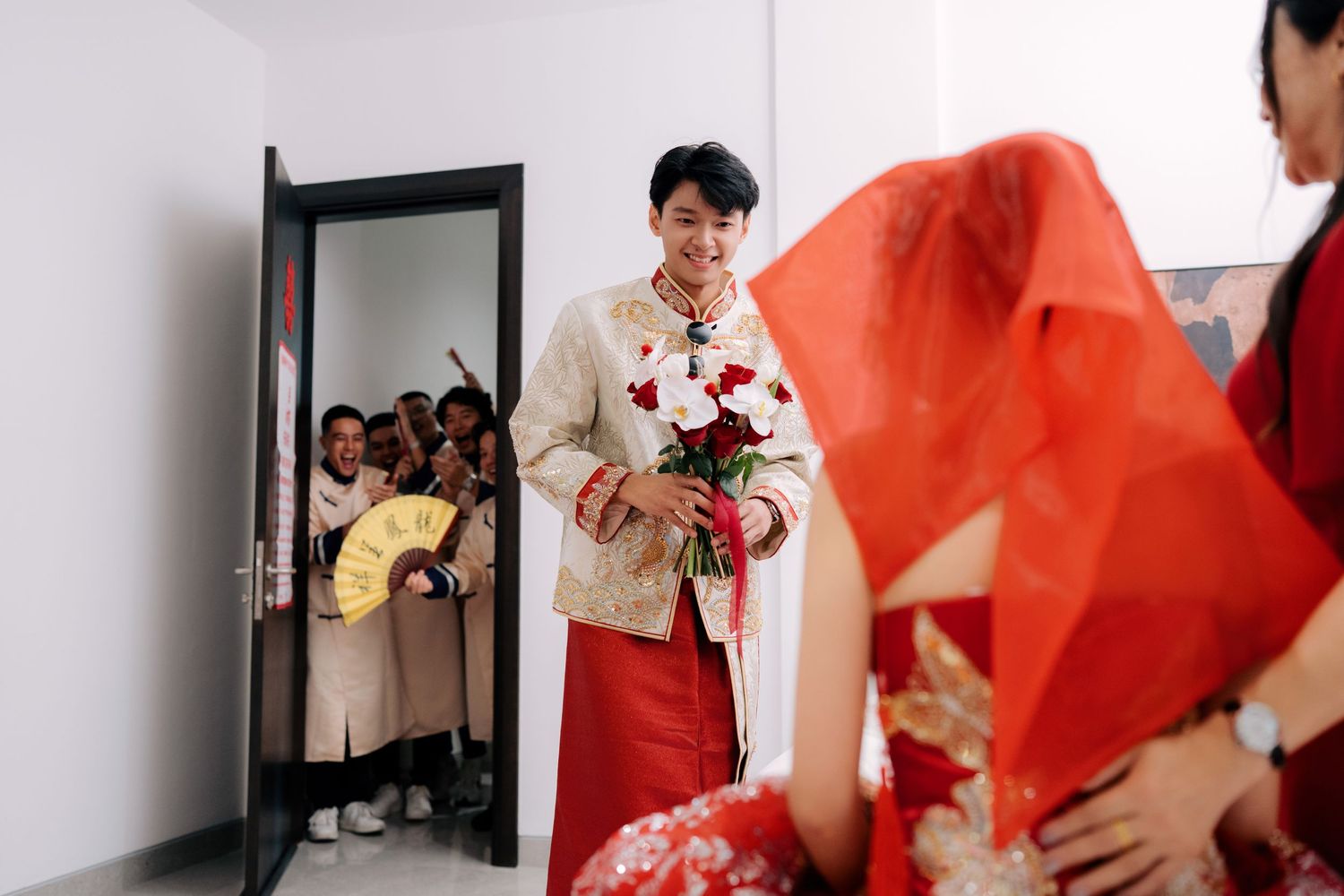 Wedding guests gather in a hallway during traditional Chinese wedding celebrations.