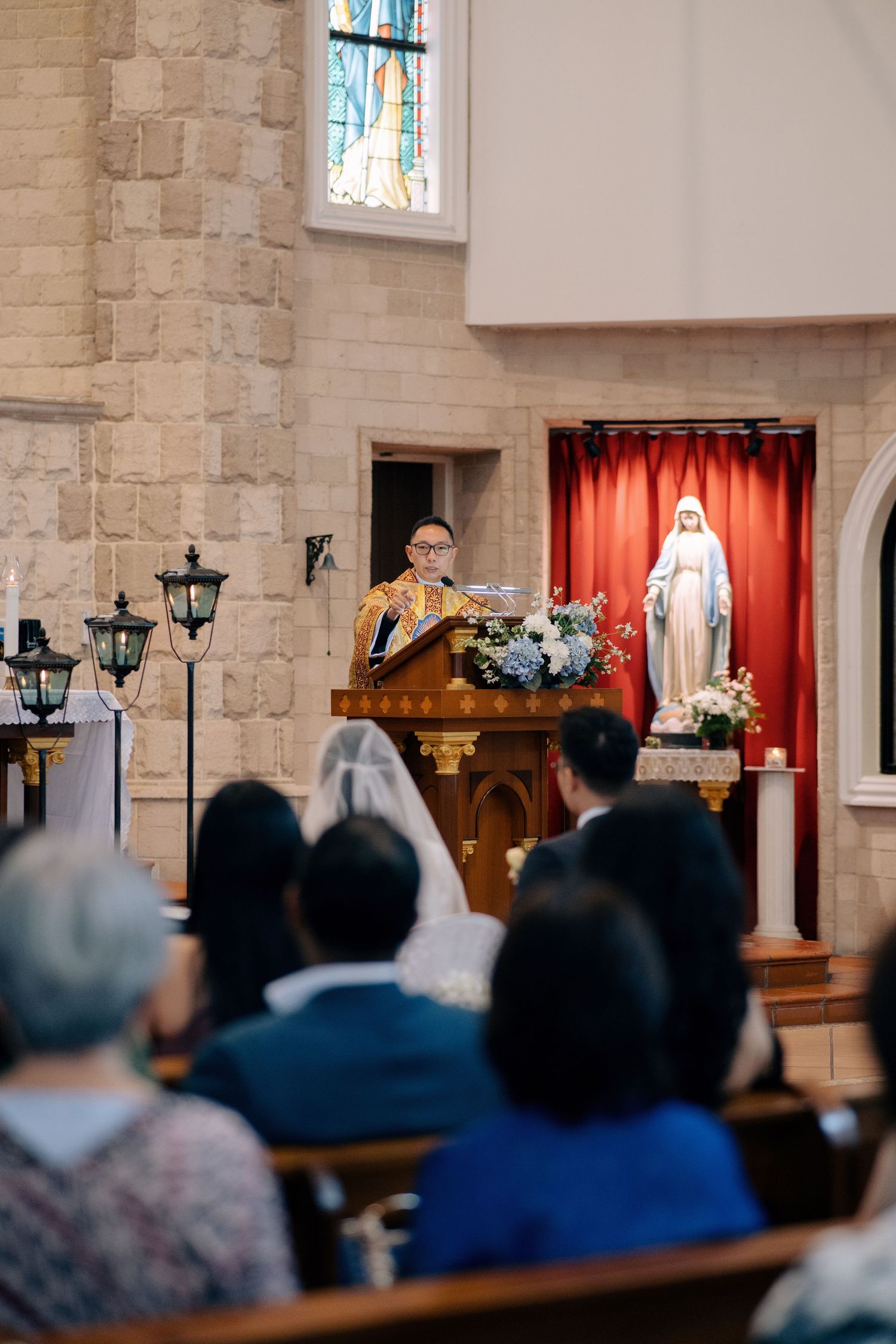 Officiant speaking to the couple and guests during a church wedding ceremony