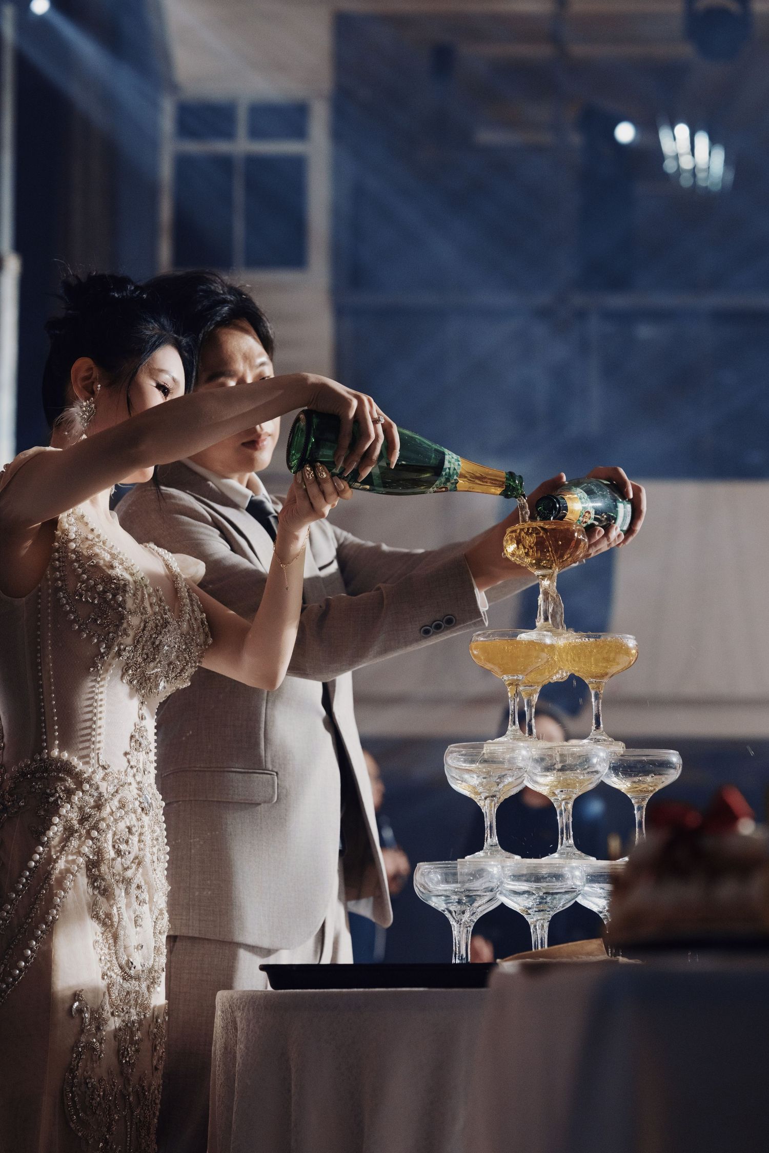 Classic wedding champagne tower pour during a luxury hotel ballroom reception