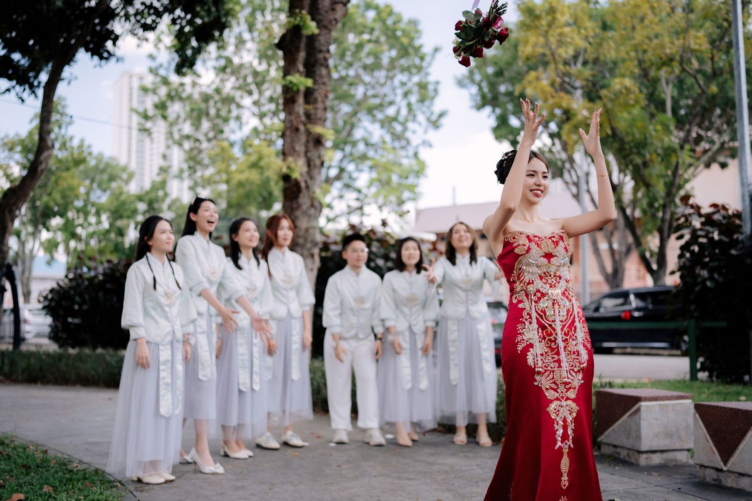 Wedding party in white dresses lined up outdoors for a group photo.