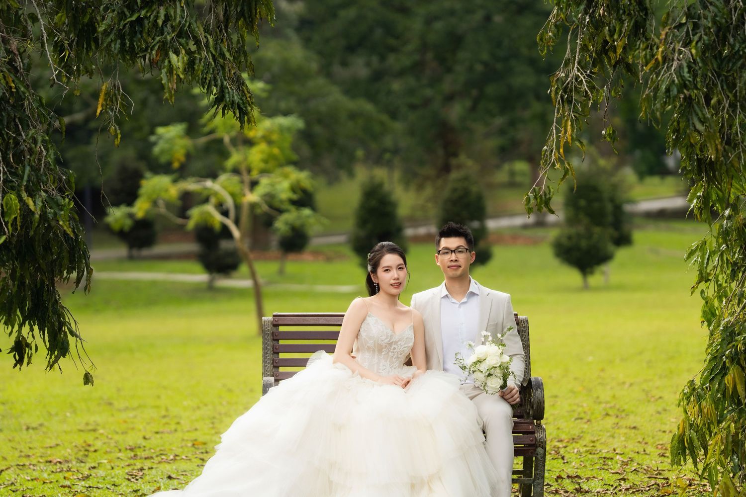 Elegant wedding photoshoot in a scenic park with rolling green lawns.