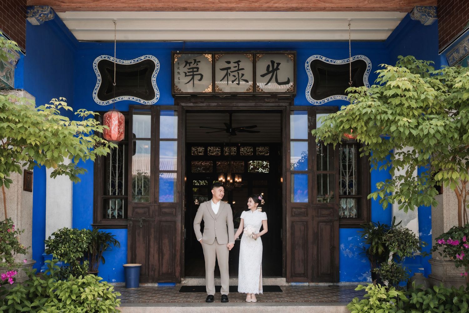 Wedding photo at Blue Mansion Penang entrance featuring historic architecture and indigo blue walls